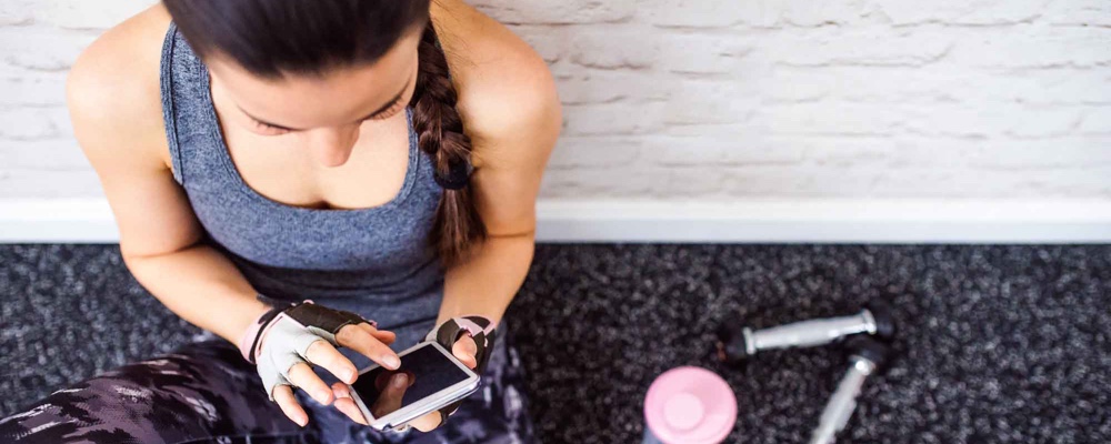 Woman in fitness gear scrolling through social media