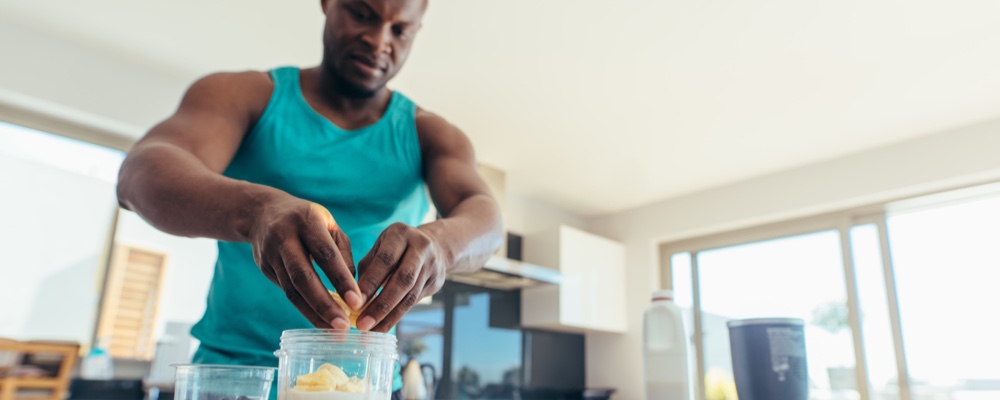 Man preparing food in kitchen before workout  