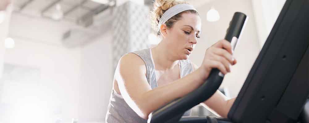 Young woman on stair climber at gym.