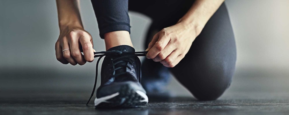 Woman tying shoe, preparing to workout  