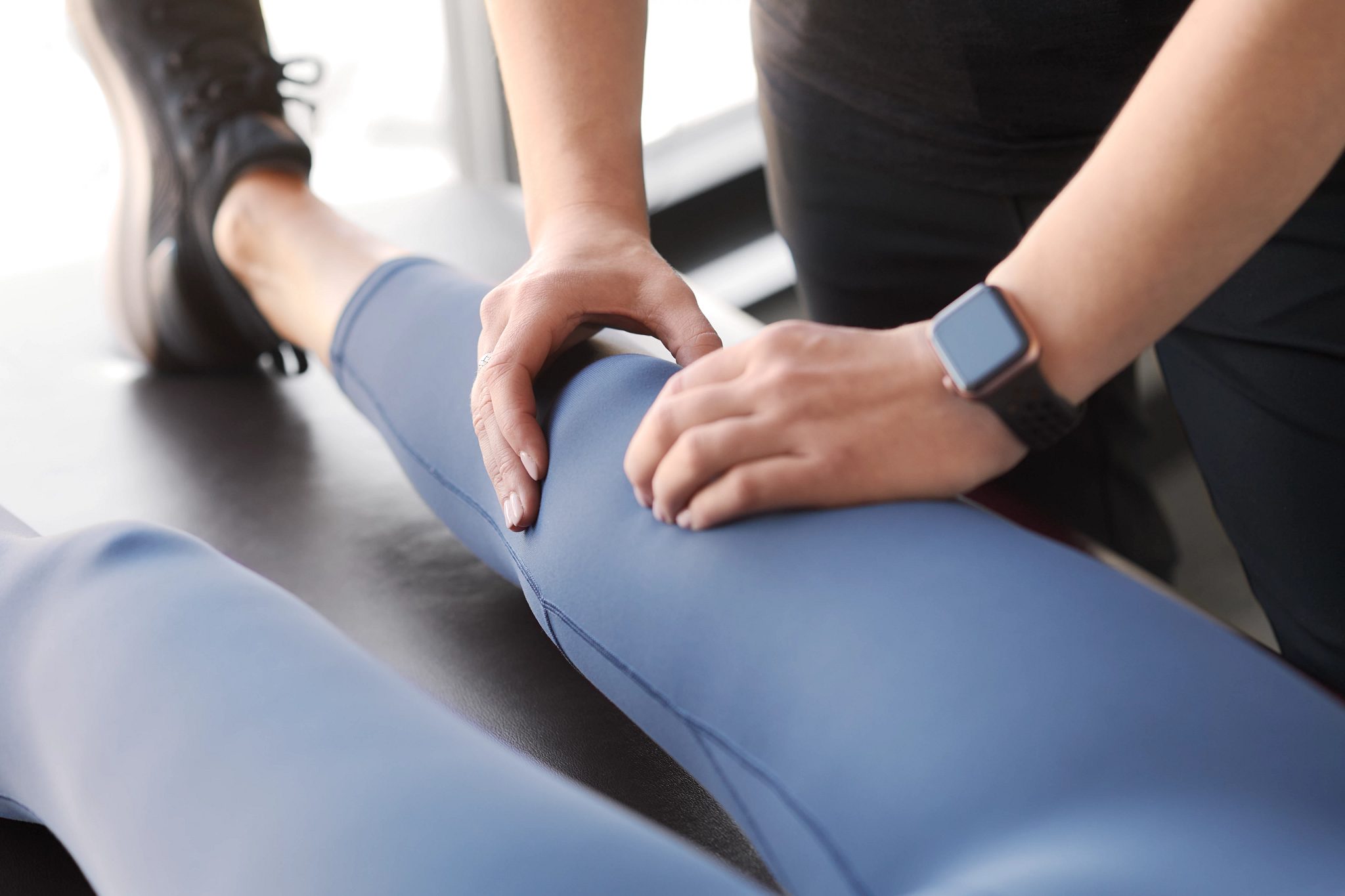 Chiropractor examining a clients kneecap