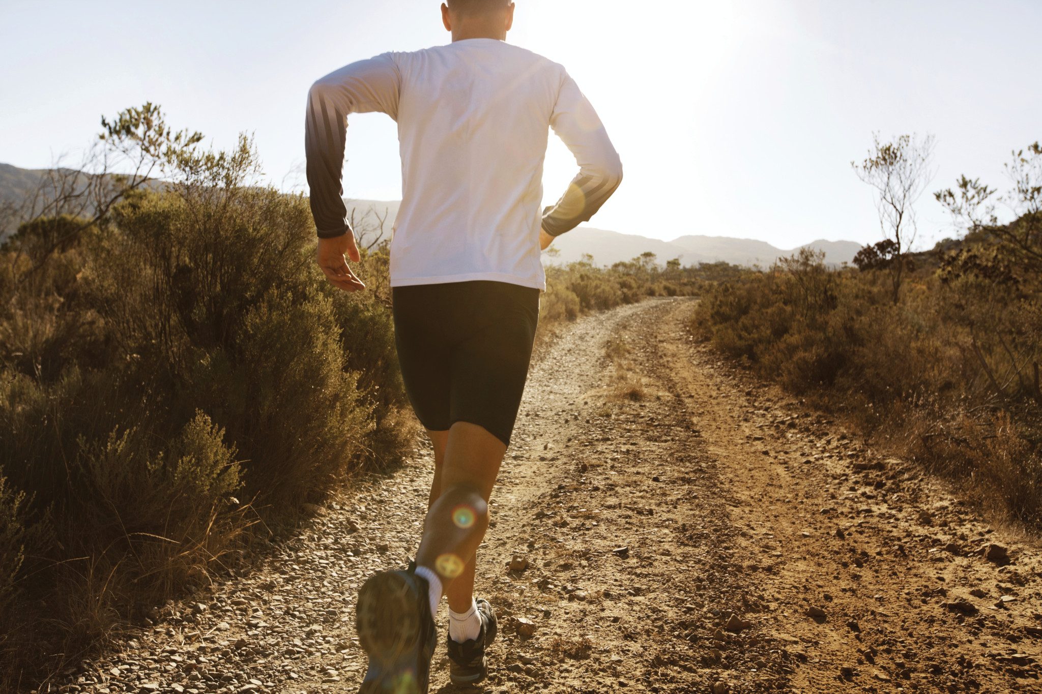 Rear view of man in sportswear running on gravel path, iStock 16993957