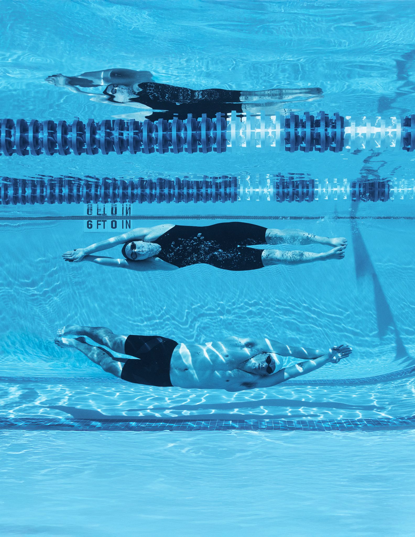 3 swimmers doing a dolphin kick underwater