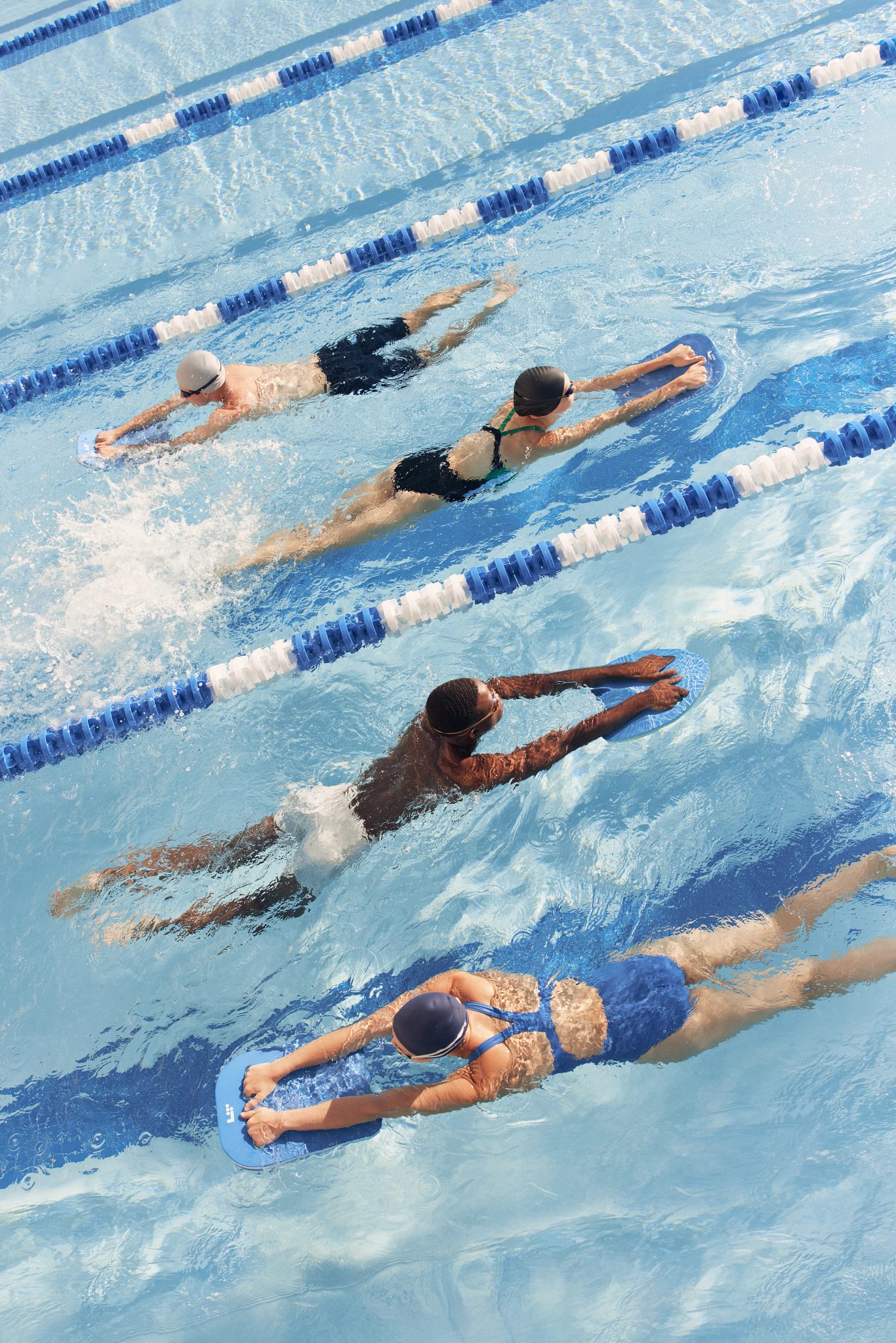 four people using kickboards in a pool