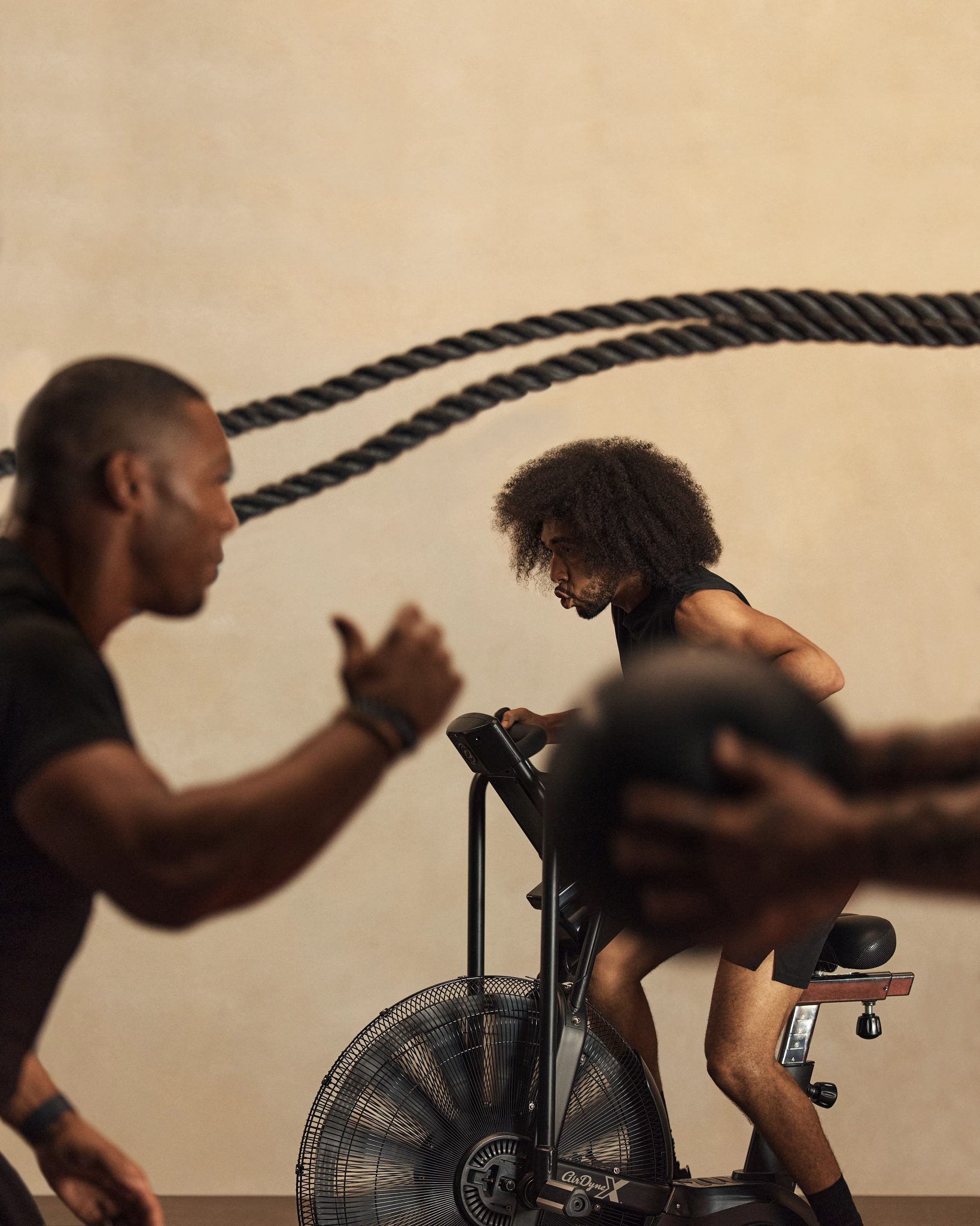 Alpha class instructor encouraging class member on stationary bike