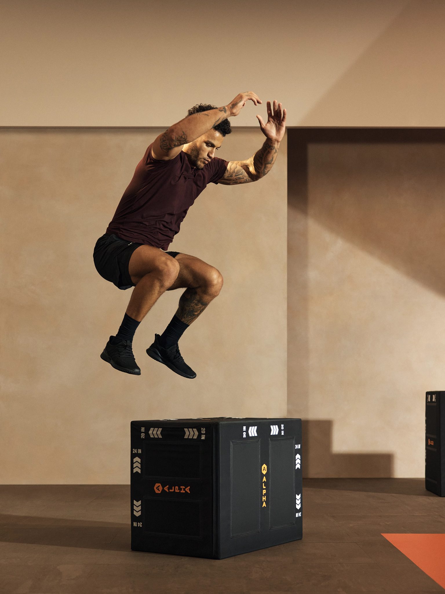 Alpha class participant jumping on to a plyo box