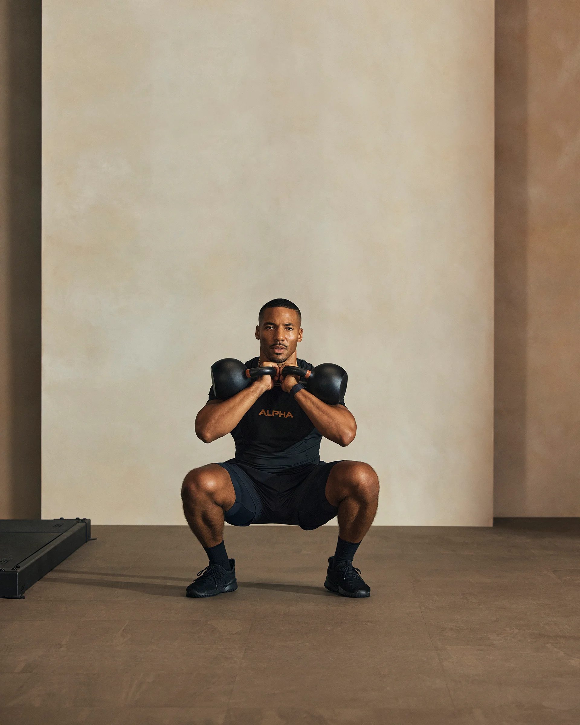 a man doing a double kettleball front rack squat