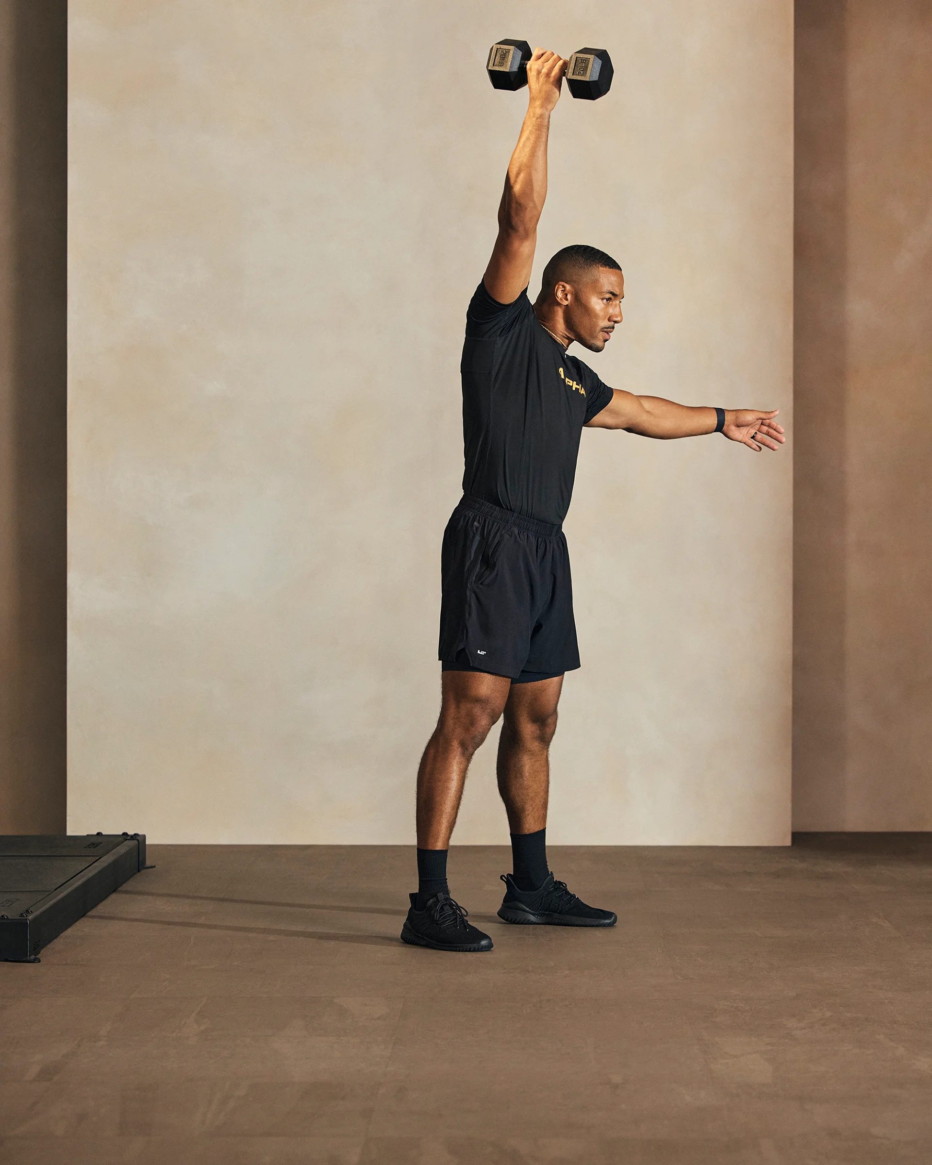 a man doing a single arm dumbell snatch