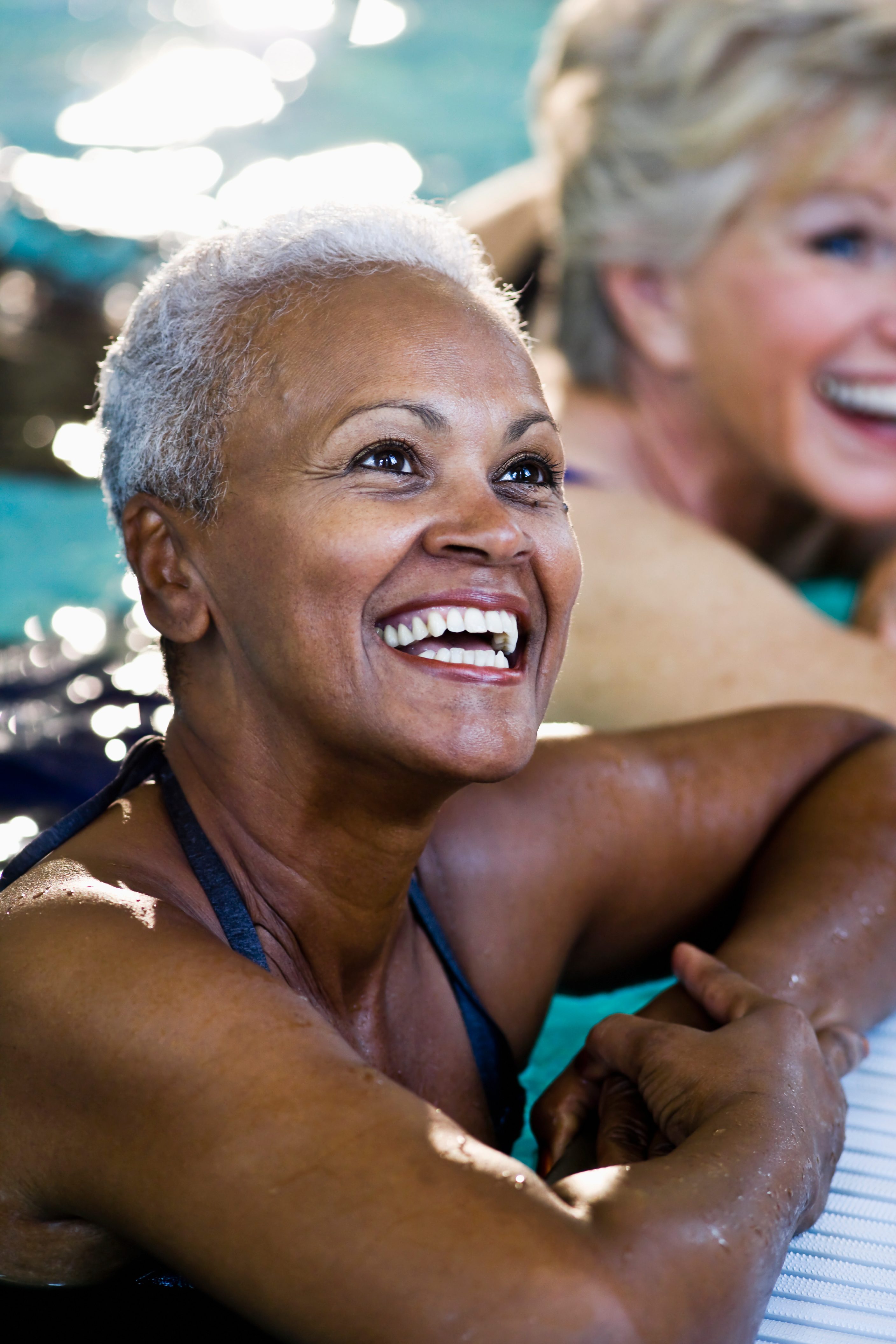 Close up of senior woman with friends (60s) at side of swimming pool