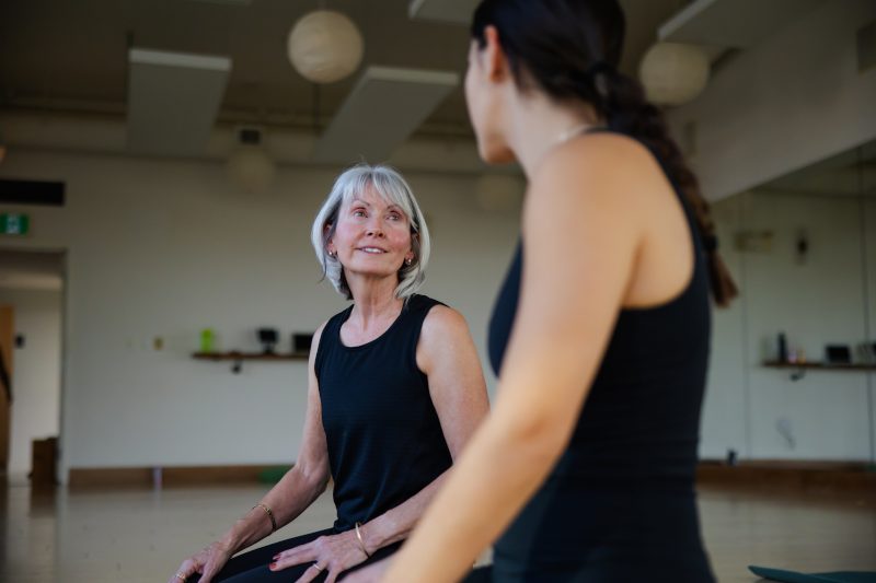 Two women chatting in a fitness room.