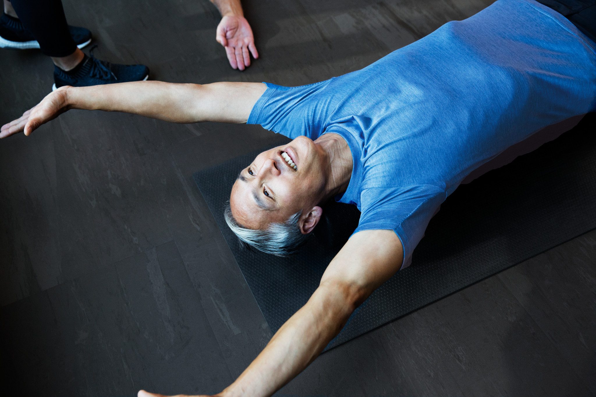 Male stretching with direction from a trainer during a personal training session