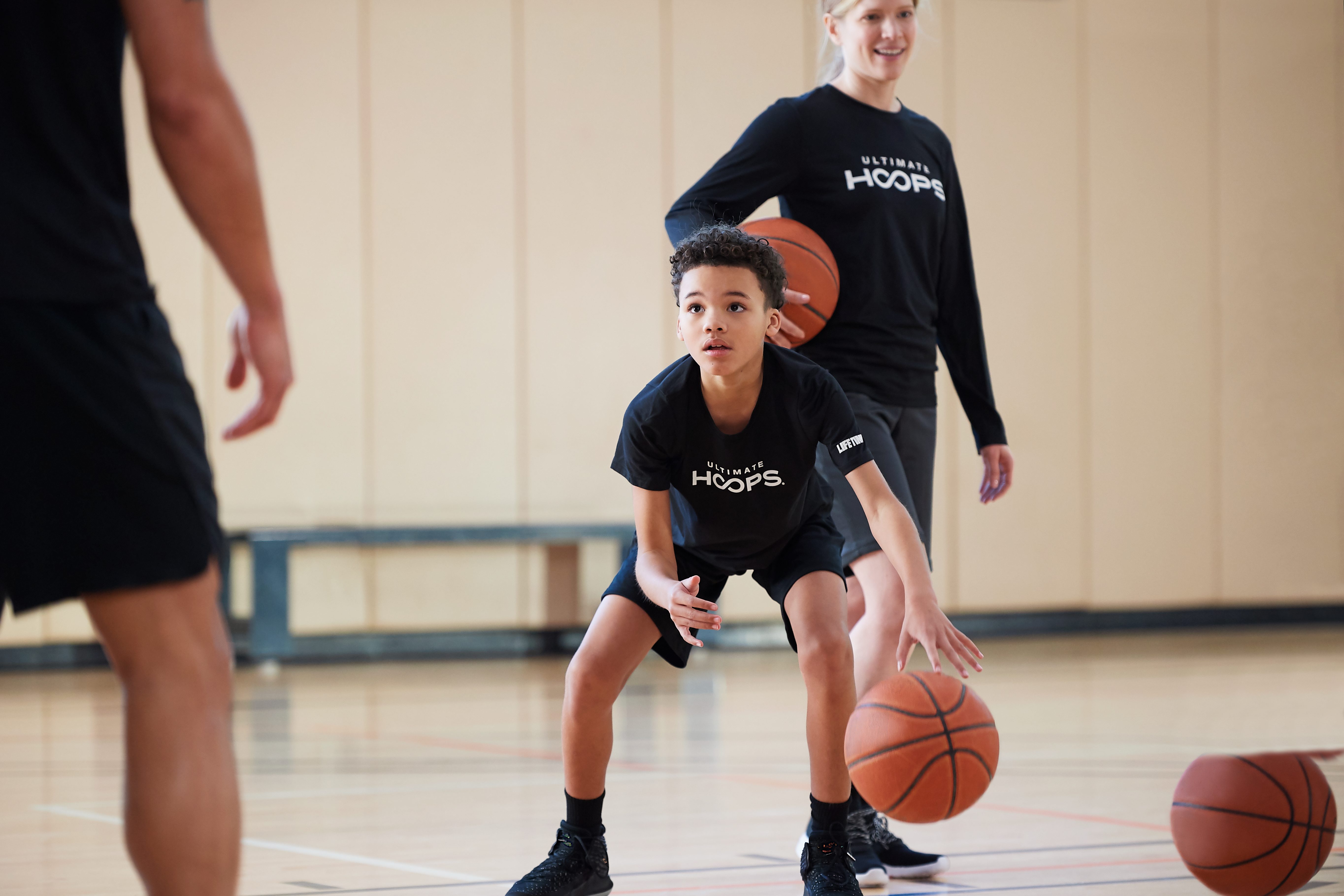 Two kids taking basketball lessons