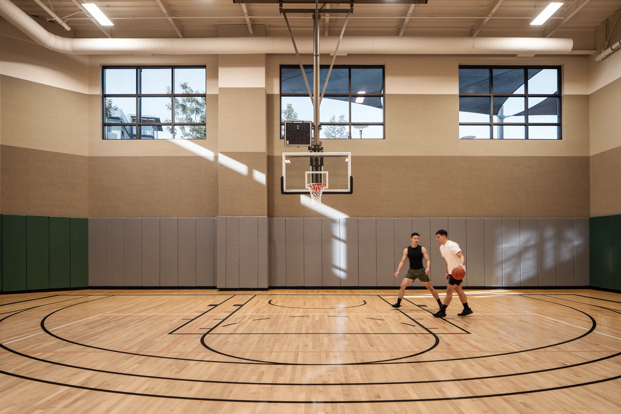 two boys playing on a basketball court