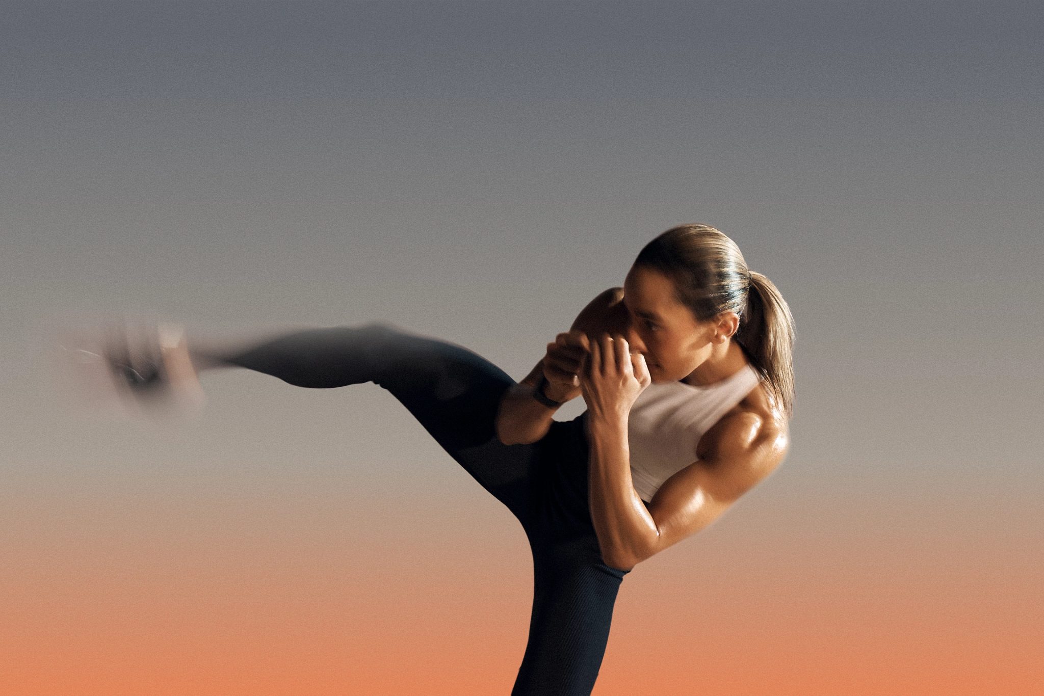Burn kickboxing class participant kicking her leg in the air
