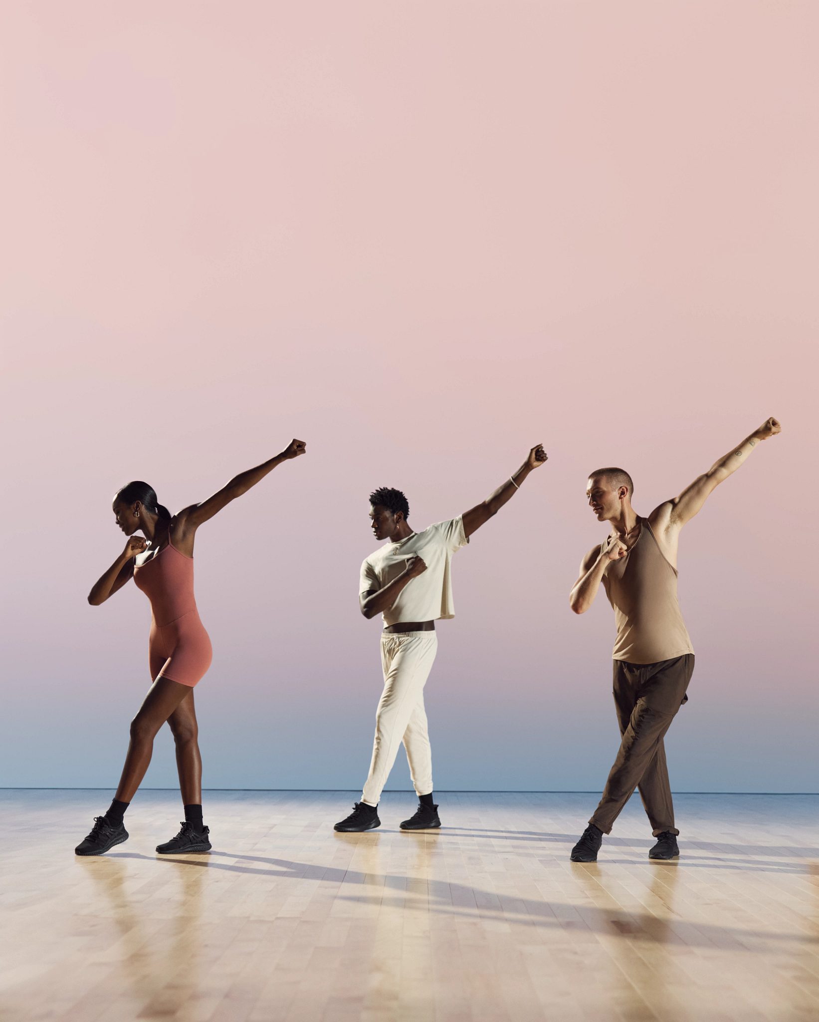Danze class participants in cross step with extended arms at Life Time