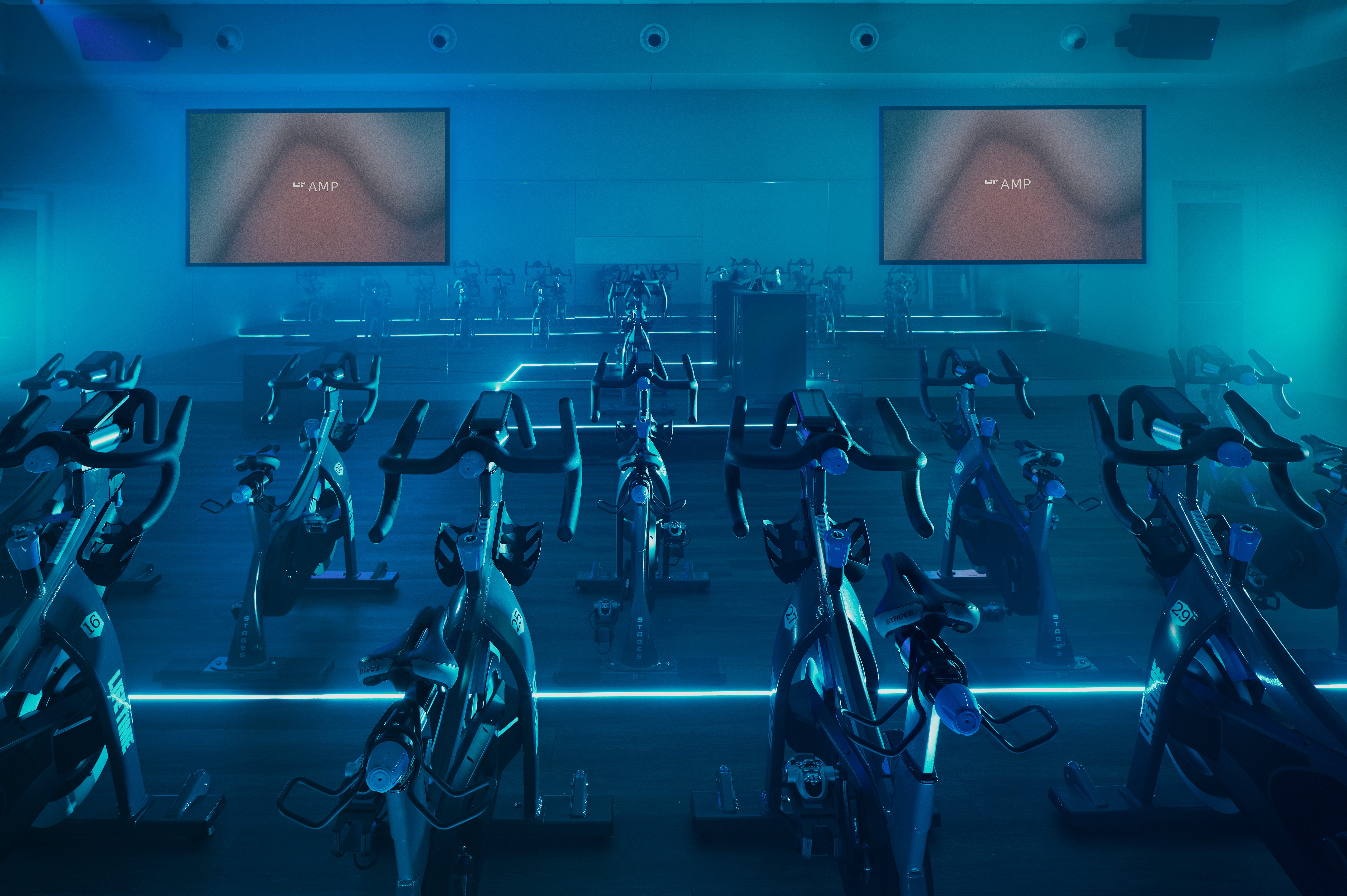 Cycle studio lit with blue lights located at the Life Time Frisco club locaton