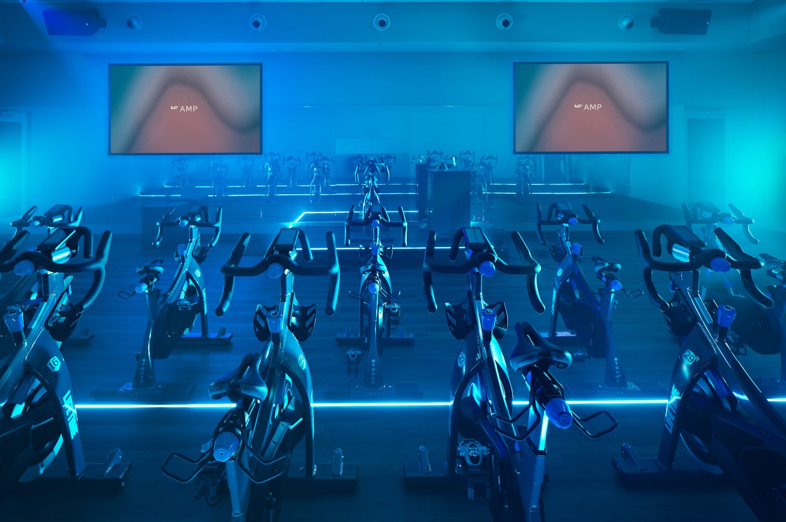 Cycle studio lit with blue lights located at the Life Time Frisco club locaton