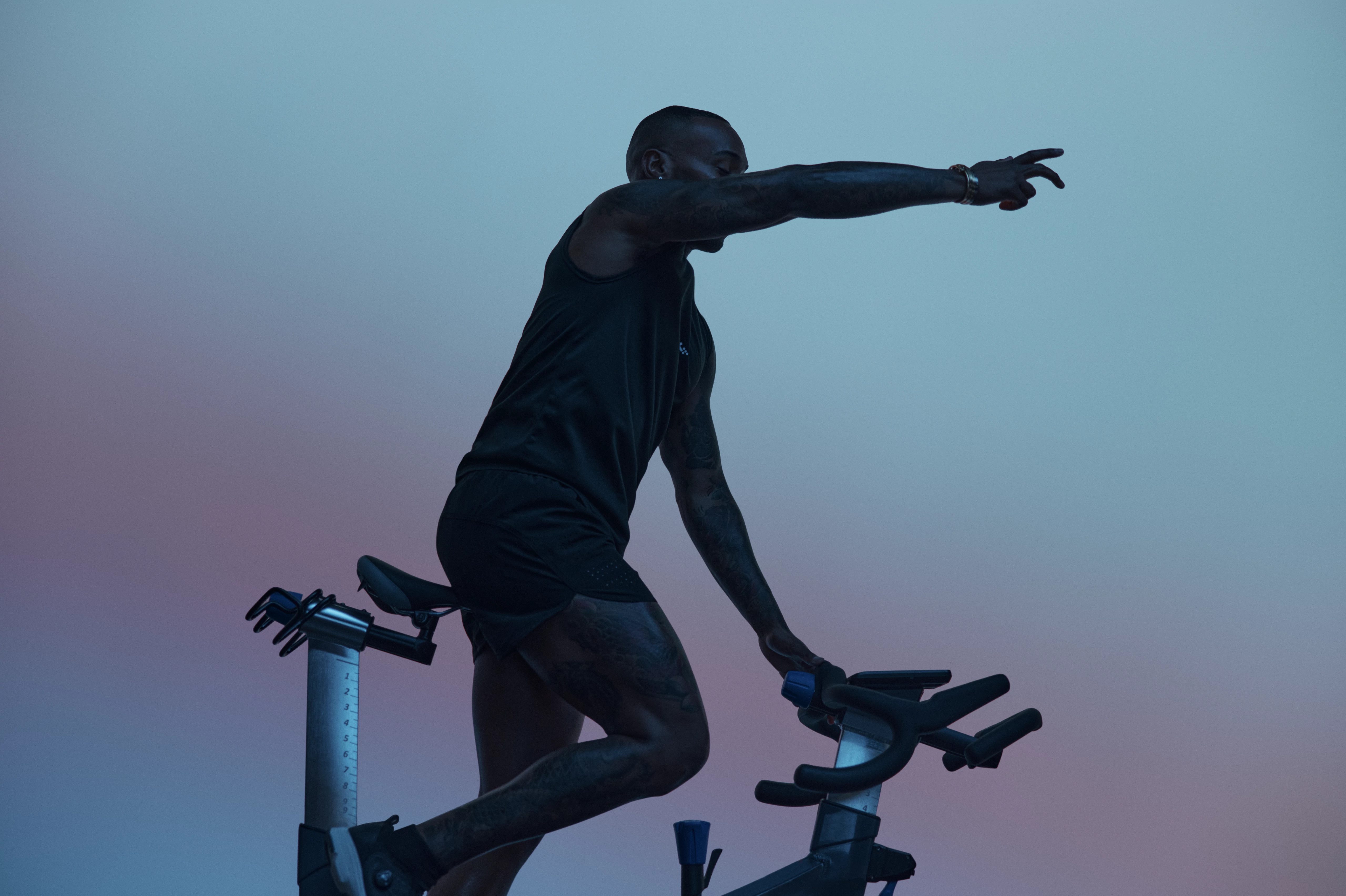 Cycling instructor in silhouette leading the AMP spin class