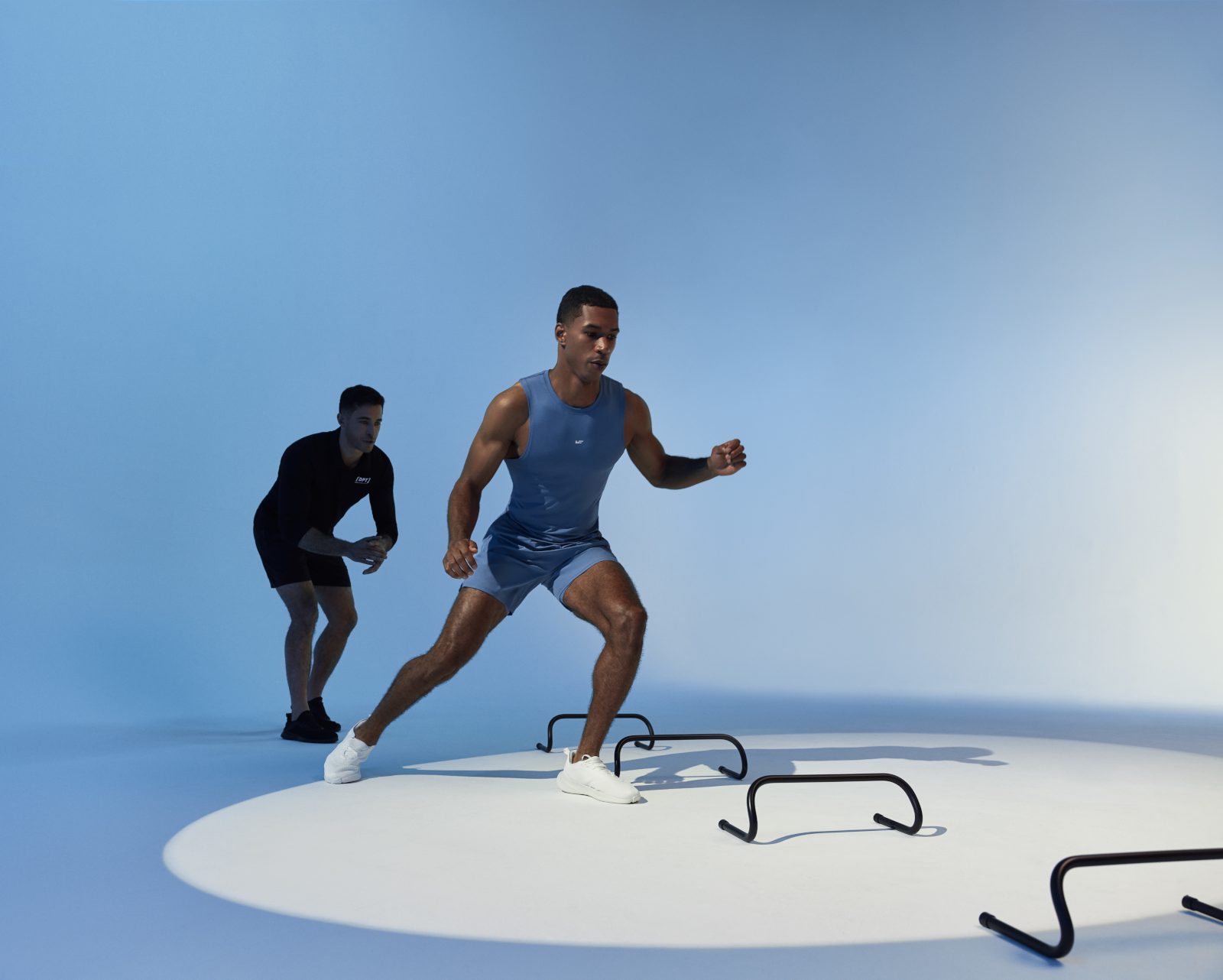 A client running through small hurdles during a training session