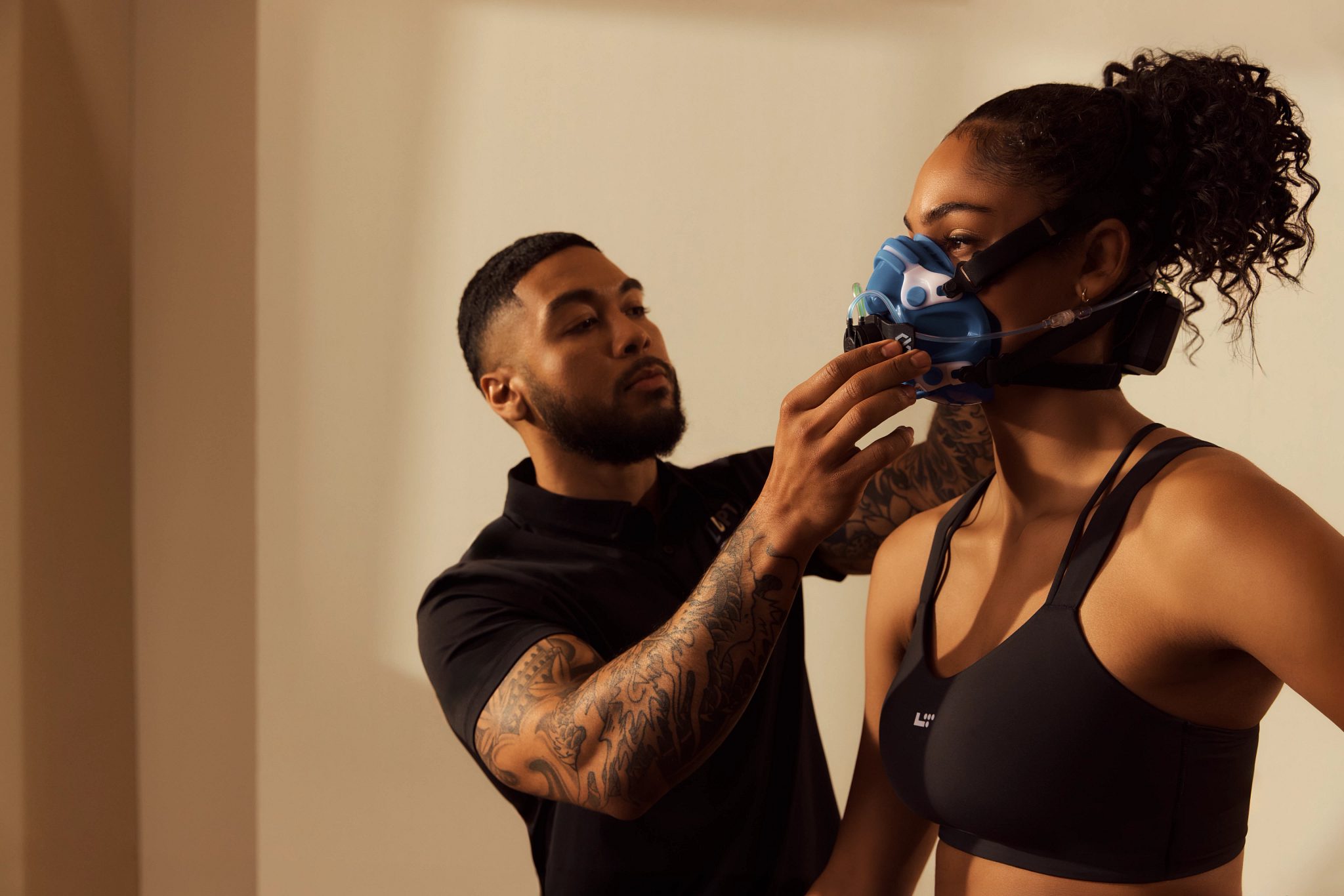 A Dynamic Personal Trainer adjusting his clients mask during an active metabolic assessment