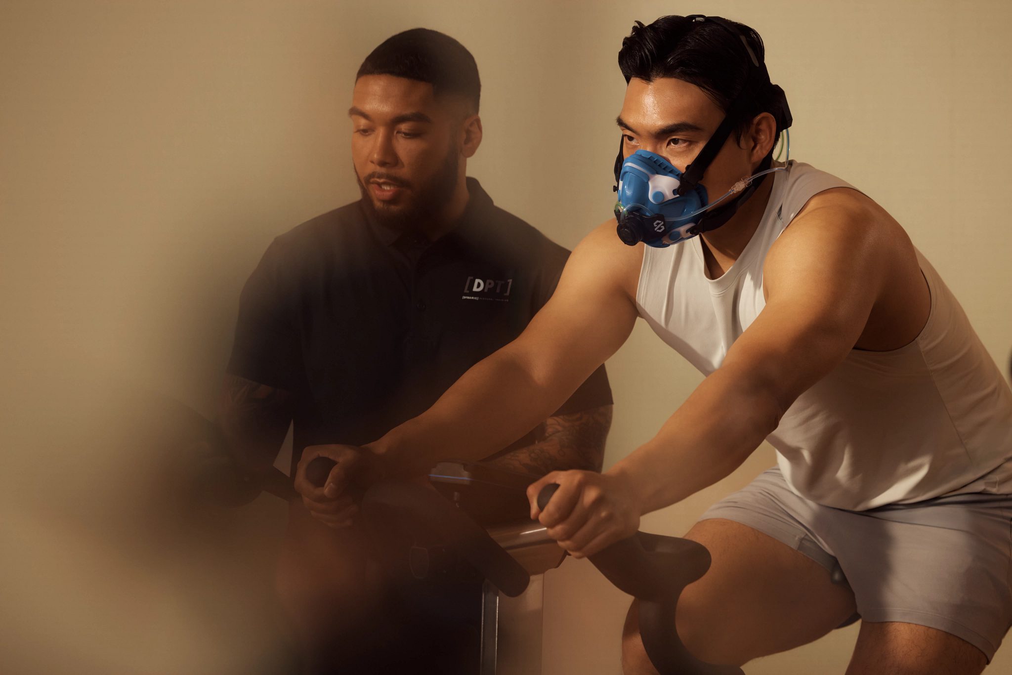 A member is wearing a mask and working out on a stationary bike during an active metabolic assessment