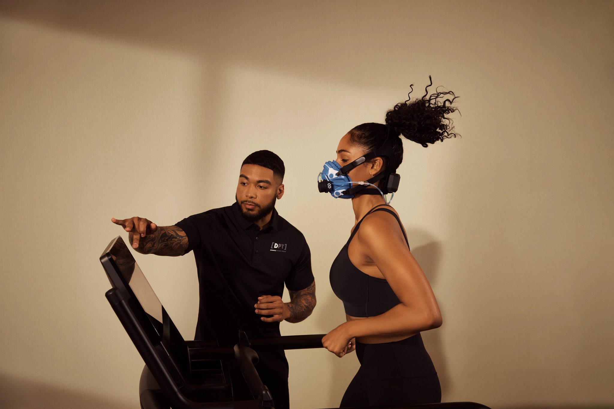 A member is wearing a mask and running on a treadmill during an active metabolic assessment