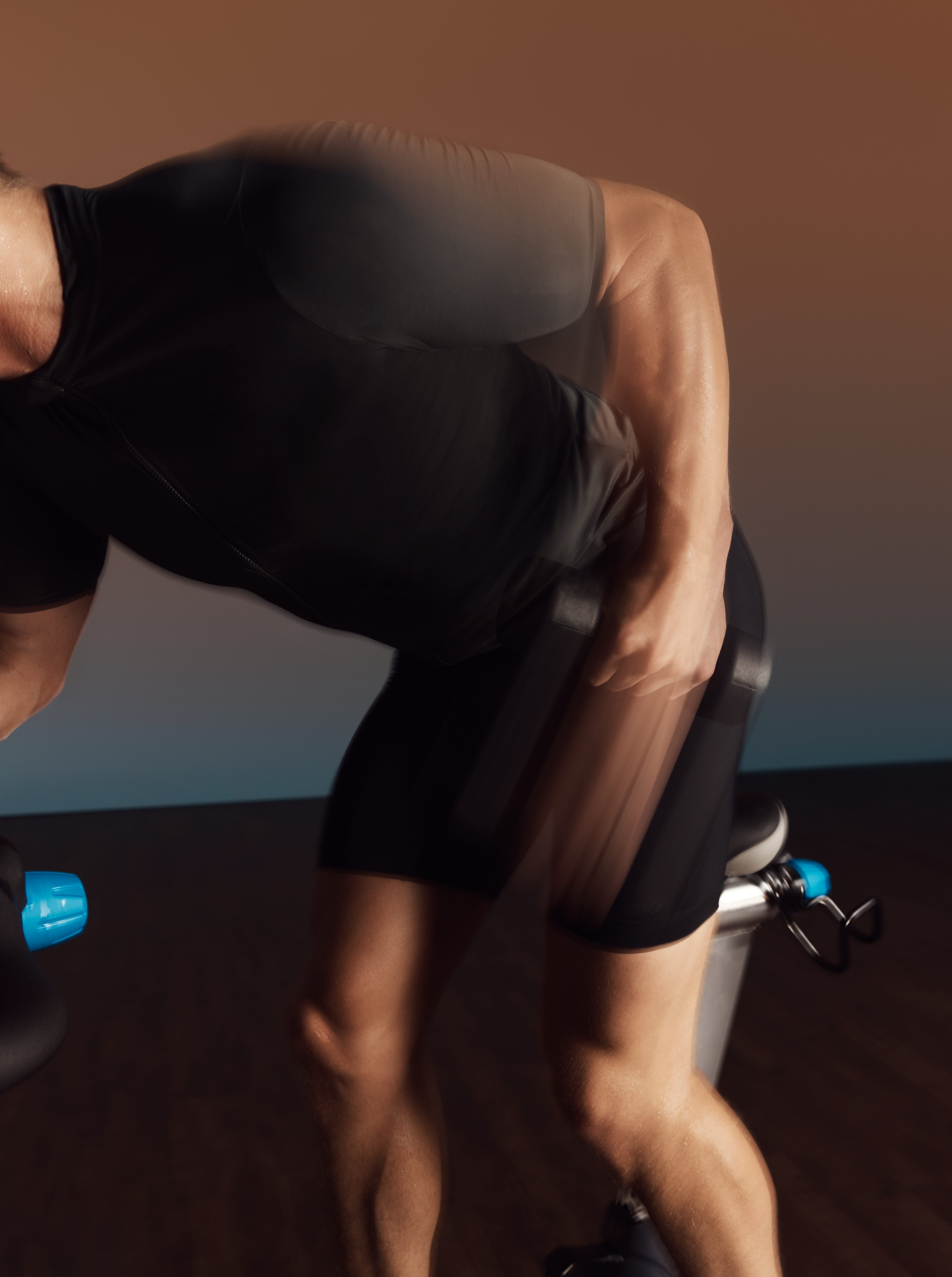 Person actively lifting a dumbbell in their left hand during an EDG spin class