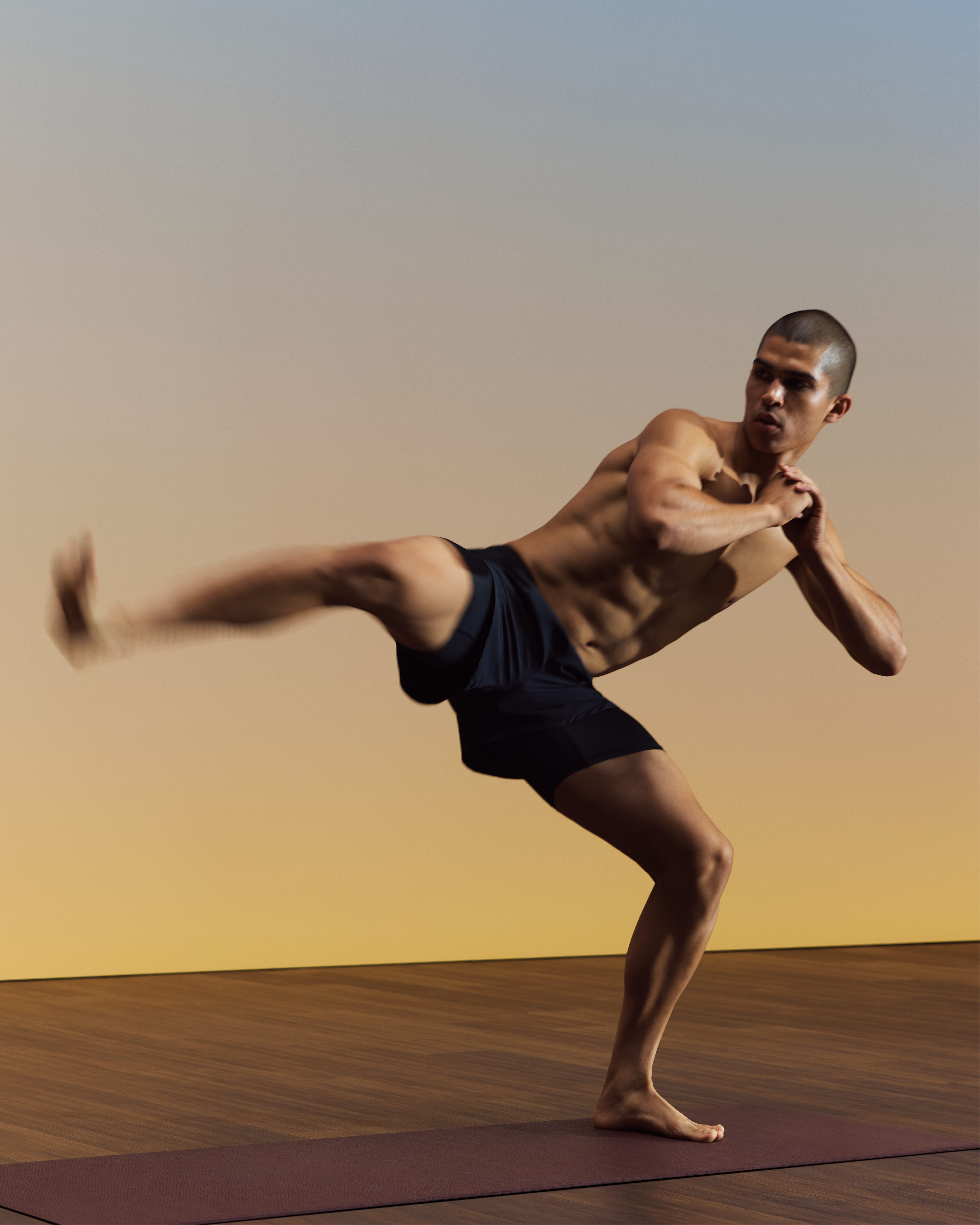 Yogi in side kick position during Life Time HIIT fire yoga class