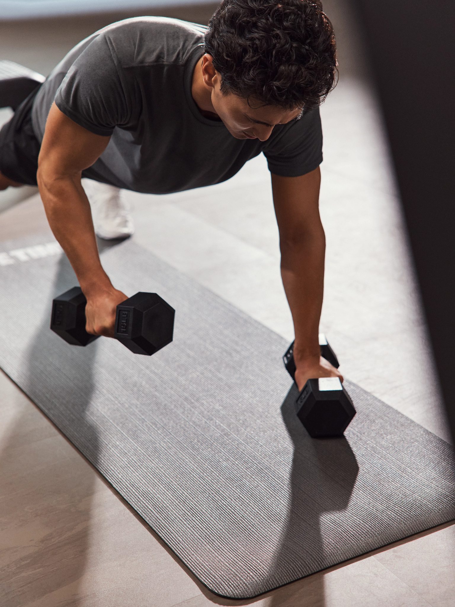 GTX class member in plank position lifting hand weights