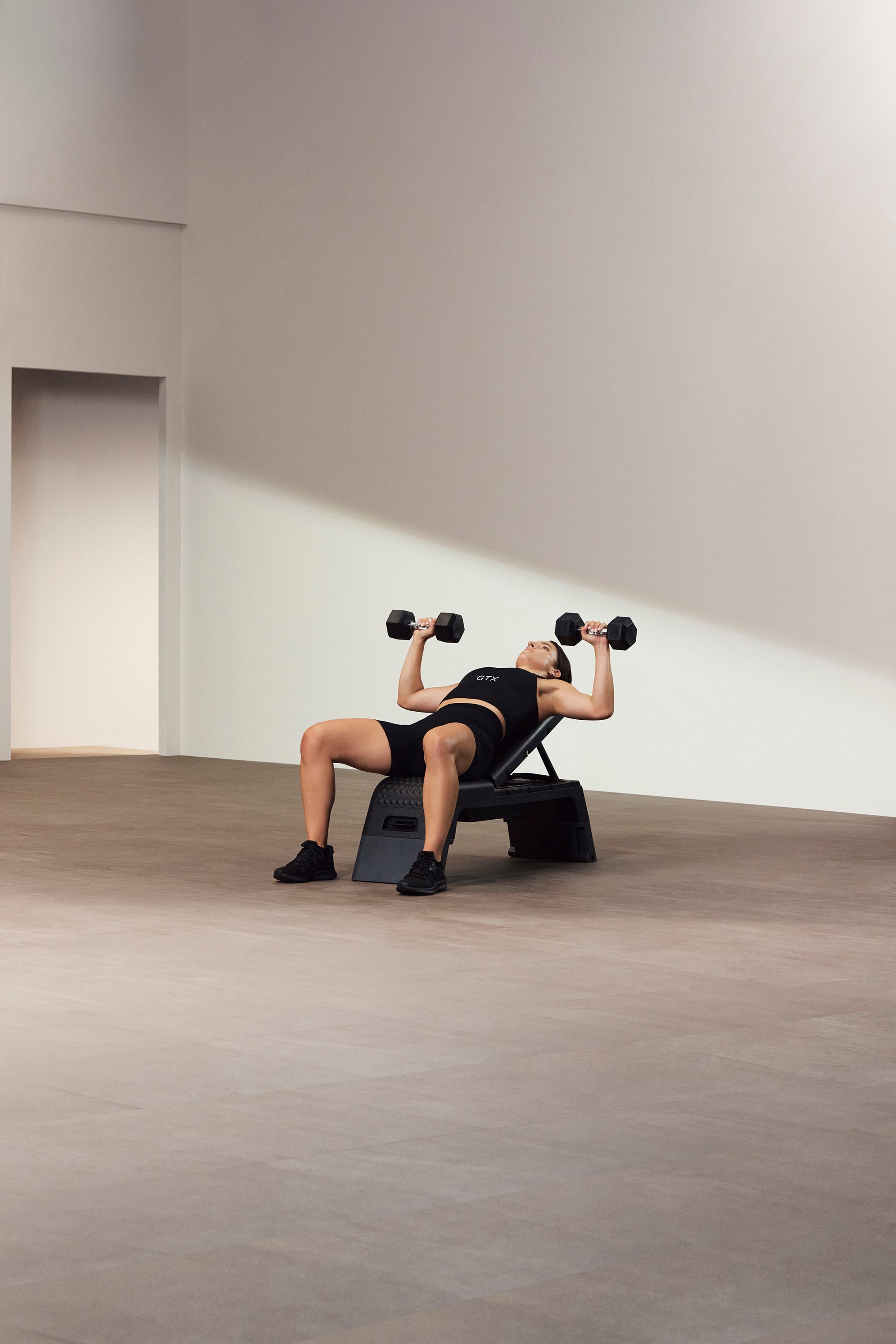 A Life Time GTX instructor demonstrating a bench press