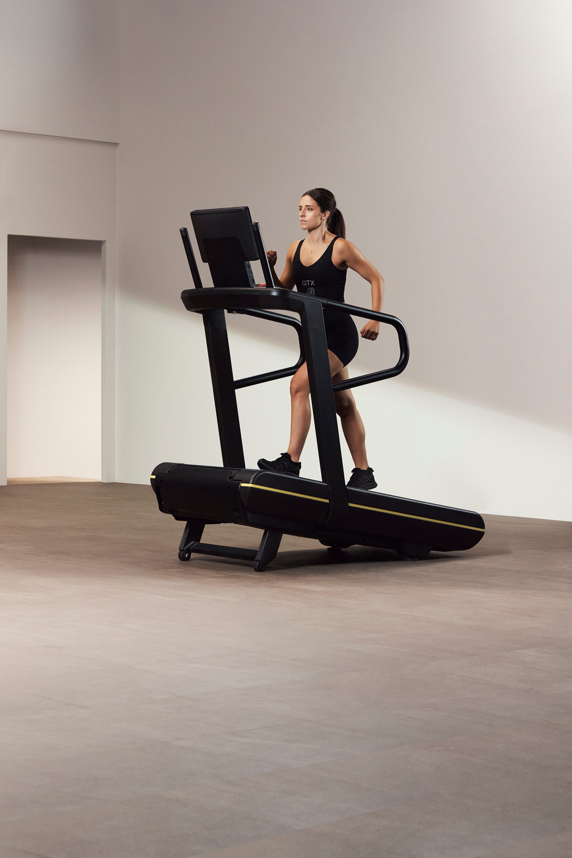 A Life Time GTX instructor demonstrating incline walk on a treadmill
