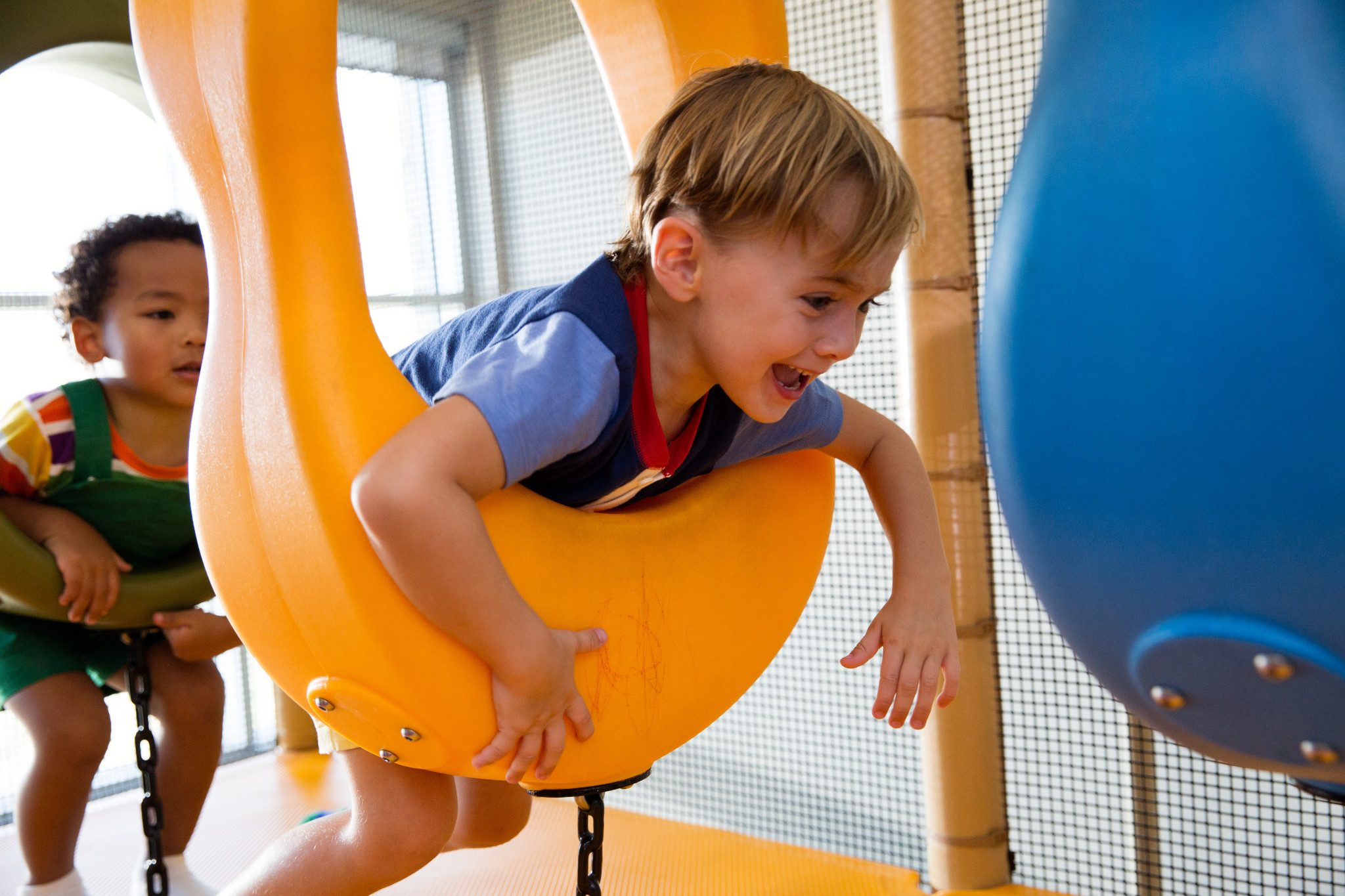 Two male children playing on an indoor playground