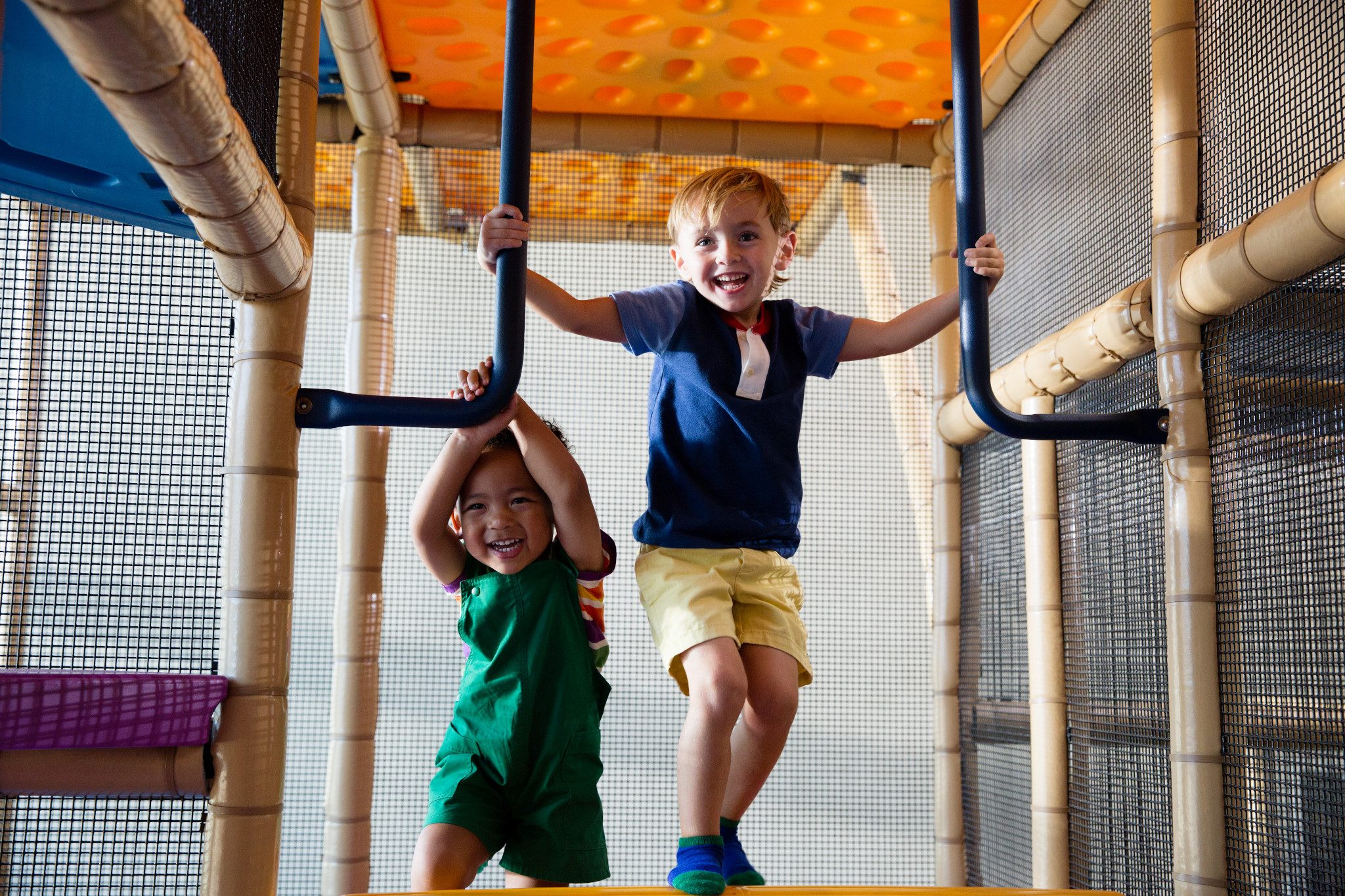 Two male children playing on an indoor playground