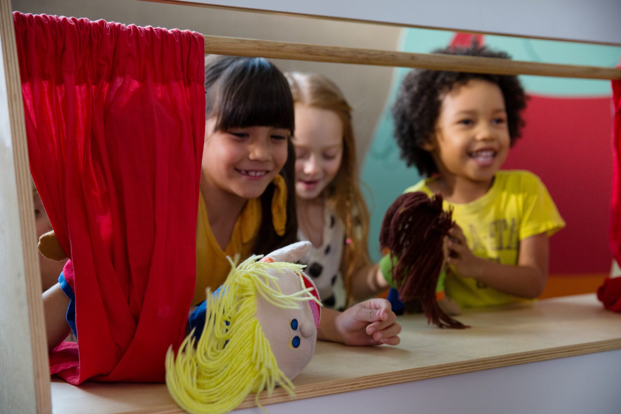 Three children playing with puppets at Life Time Kids Academy