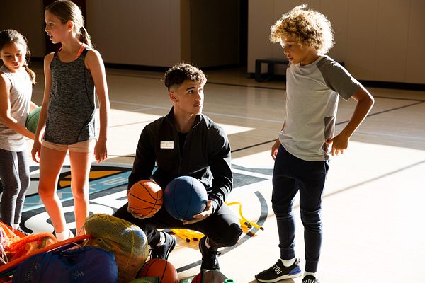 a boy learning basketball from an instructor