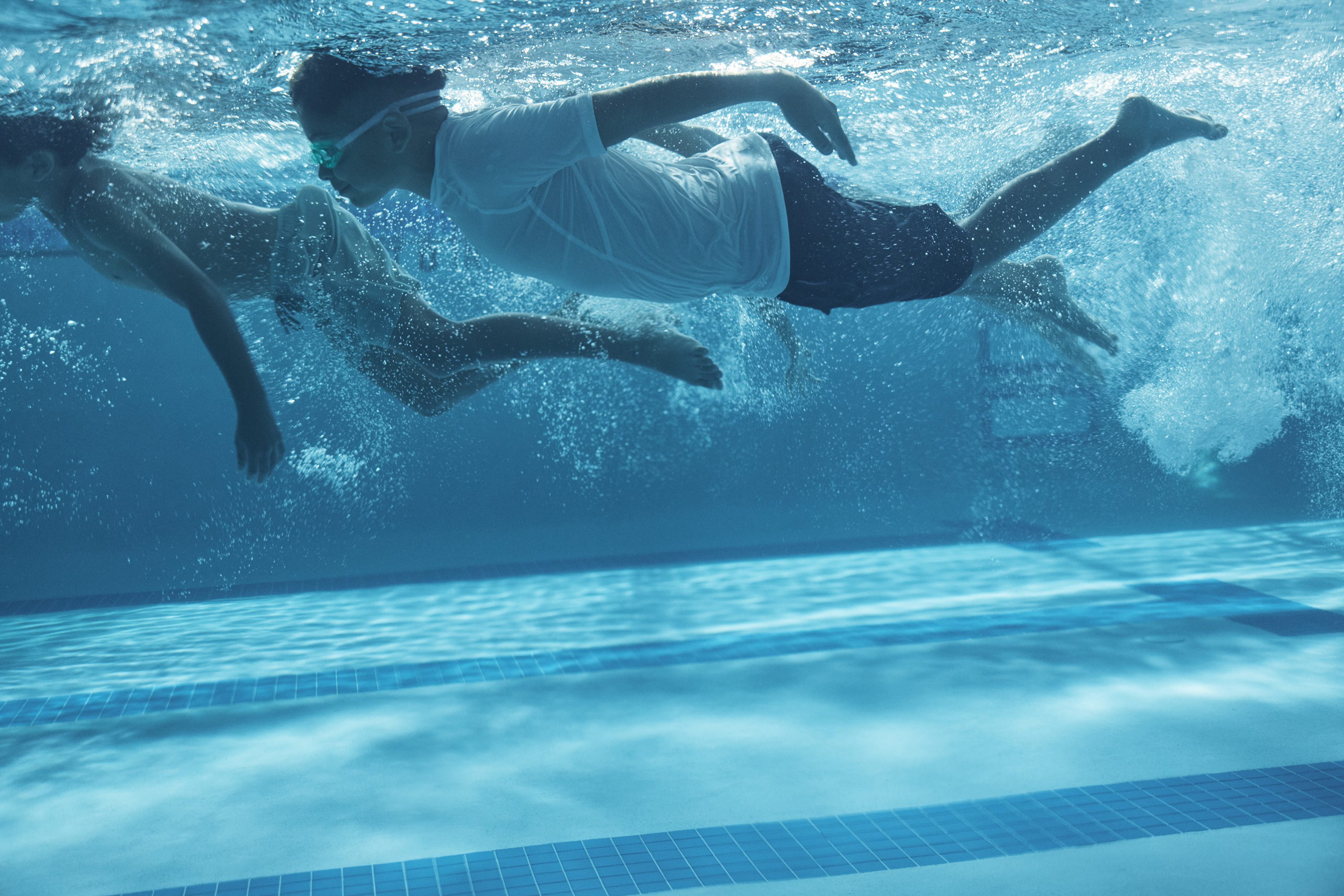 two boys swimming under water
