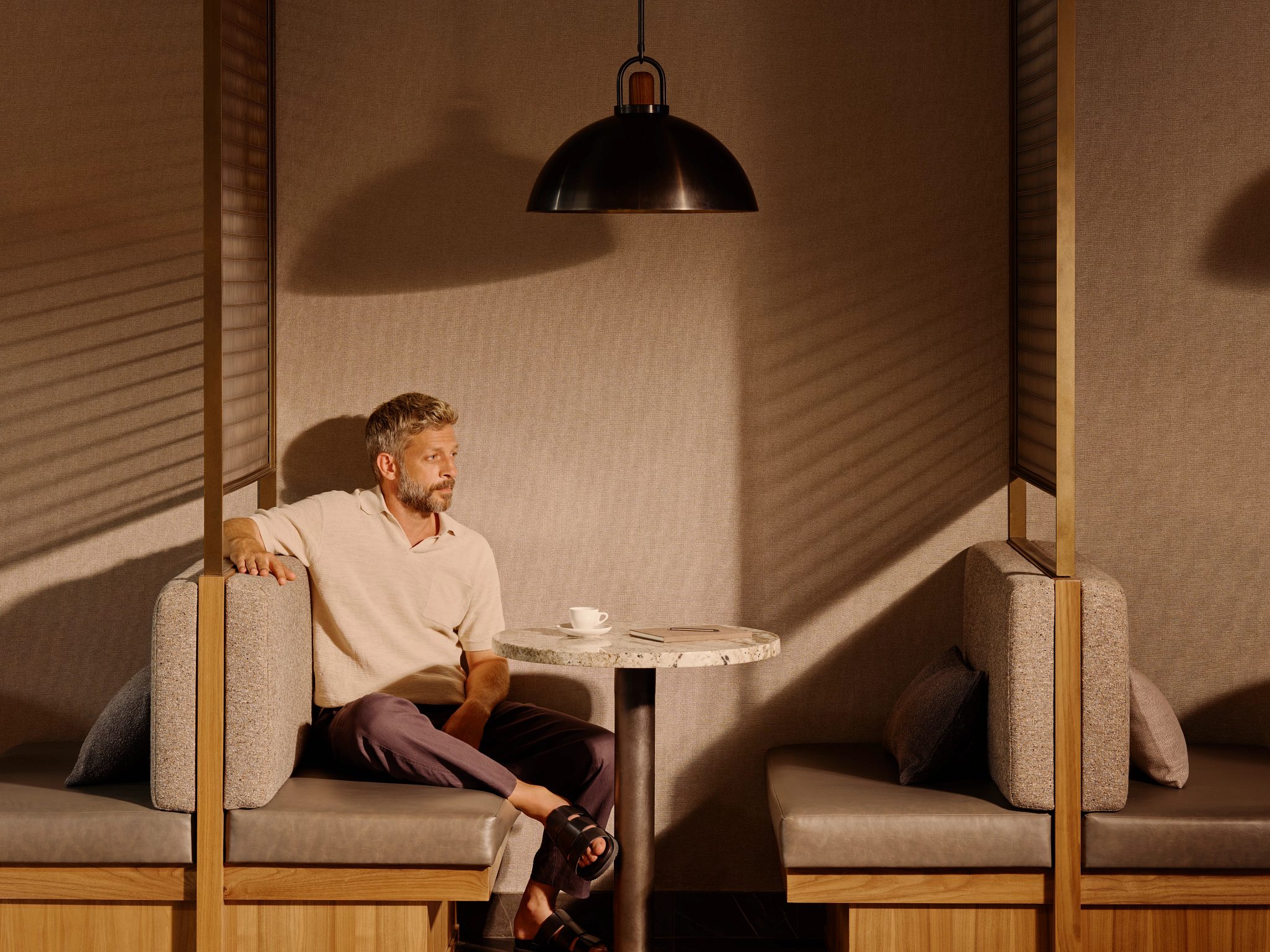 A man sitting in a booth enjoying a cup of coffee