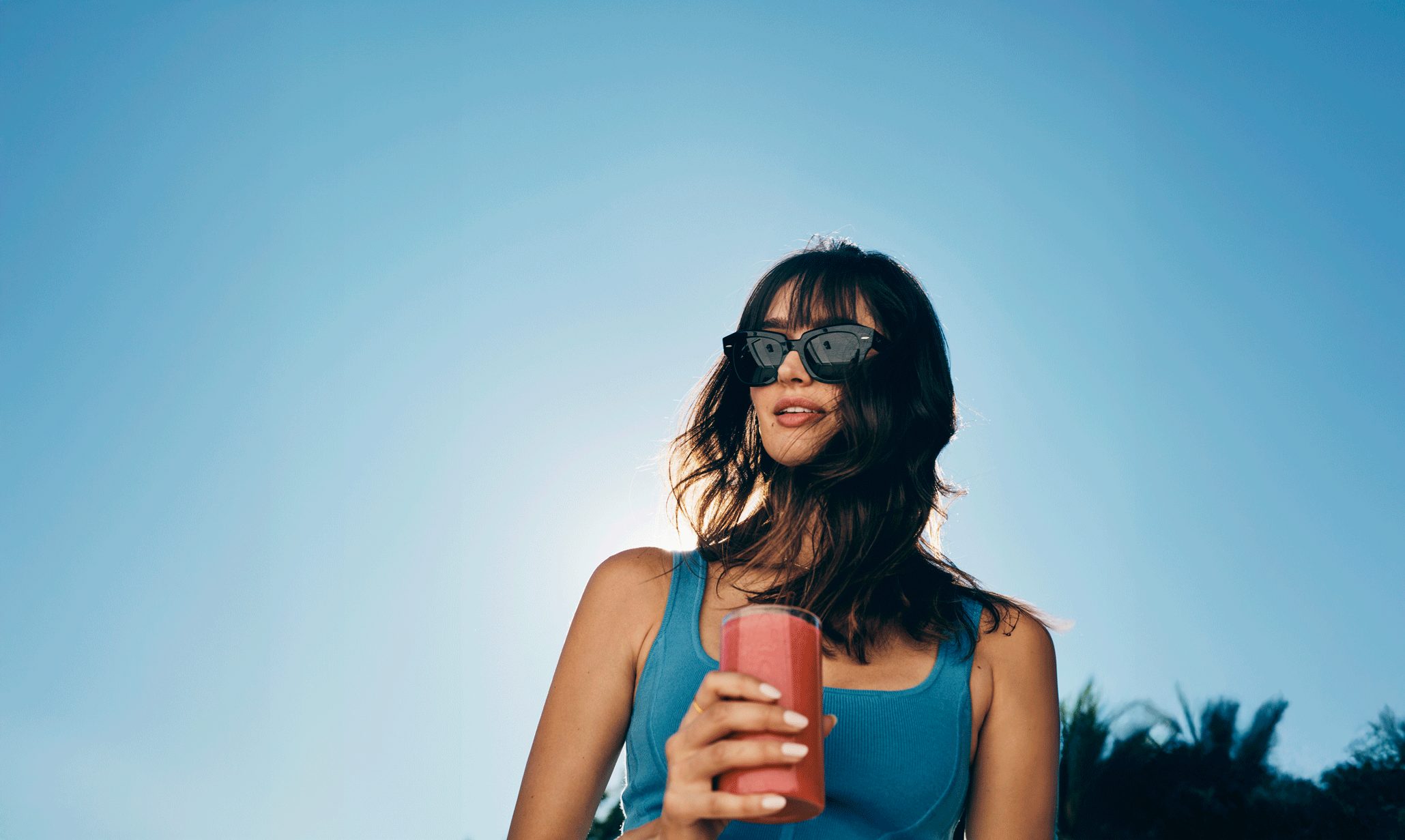 woman standing outside holding a smoothie