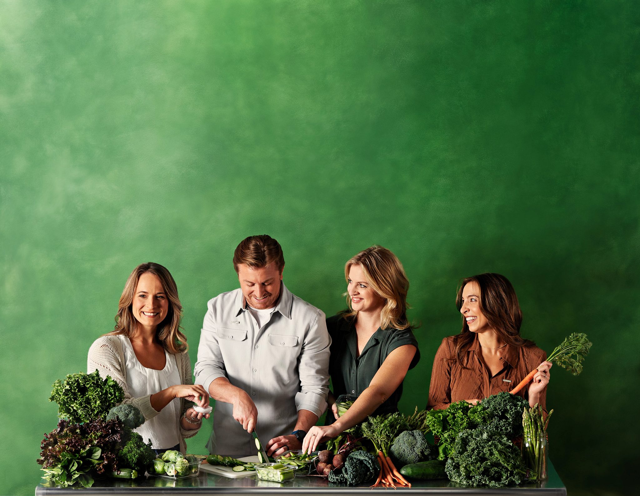 Portrait of Life Time Weightloss coaches surrounded by fresh produce on a green background