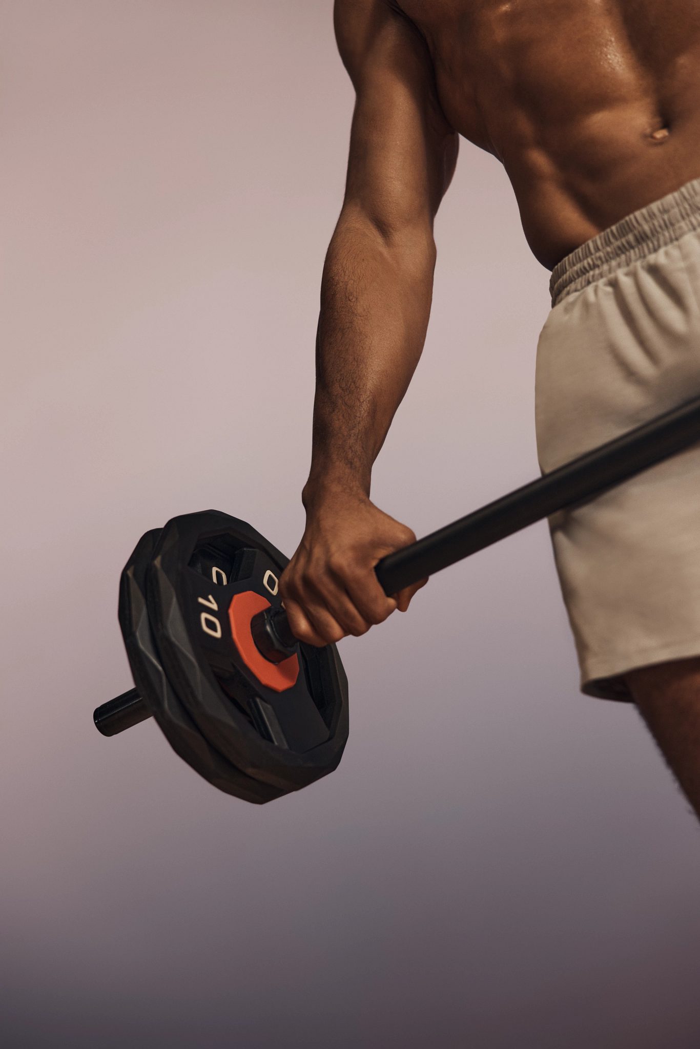 Stylized image of a shirtless Life Time member holding a barbell in a Lift strength class