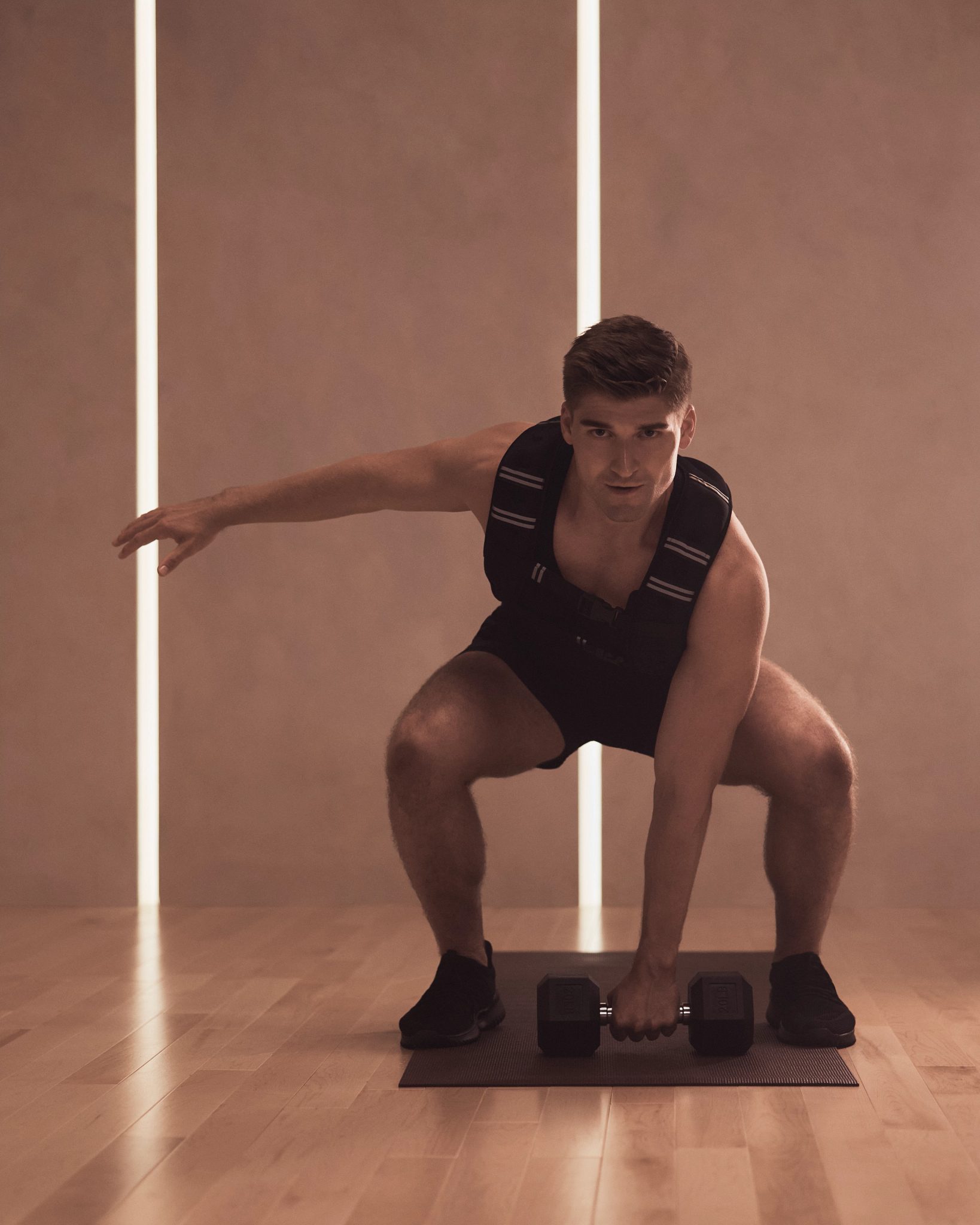 MB360 boutique group training class member readying for a weighted squat