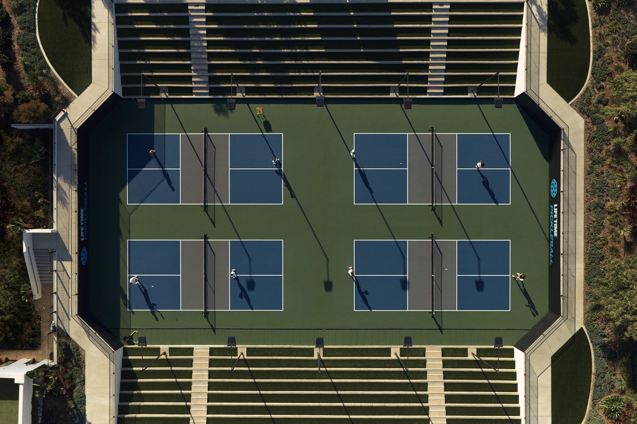 An aerial view of Life Time members playing on four outdoor pickleball courts