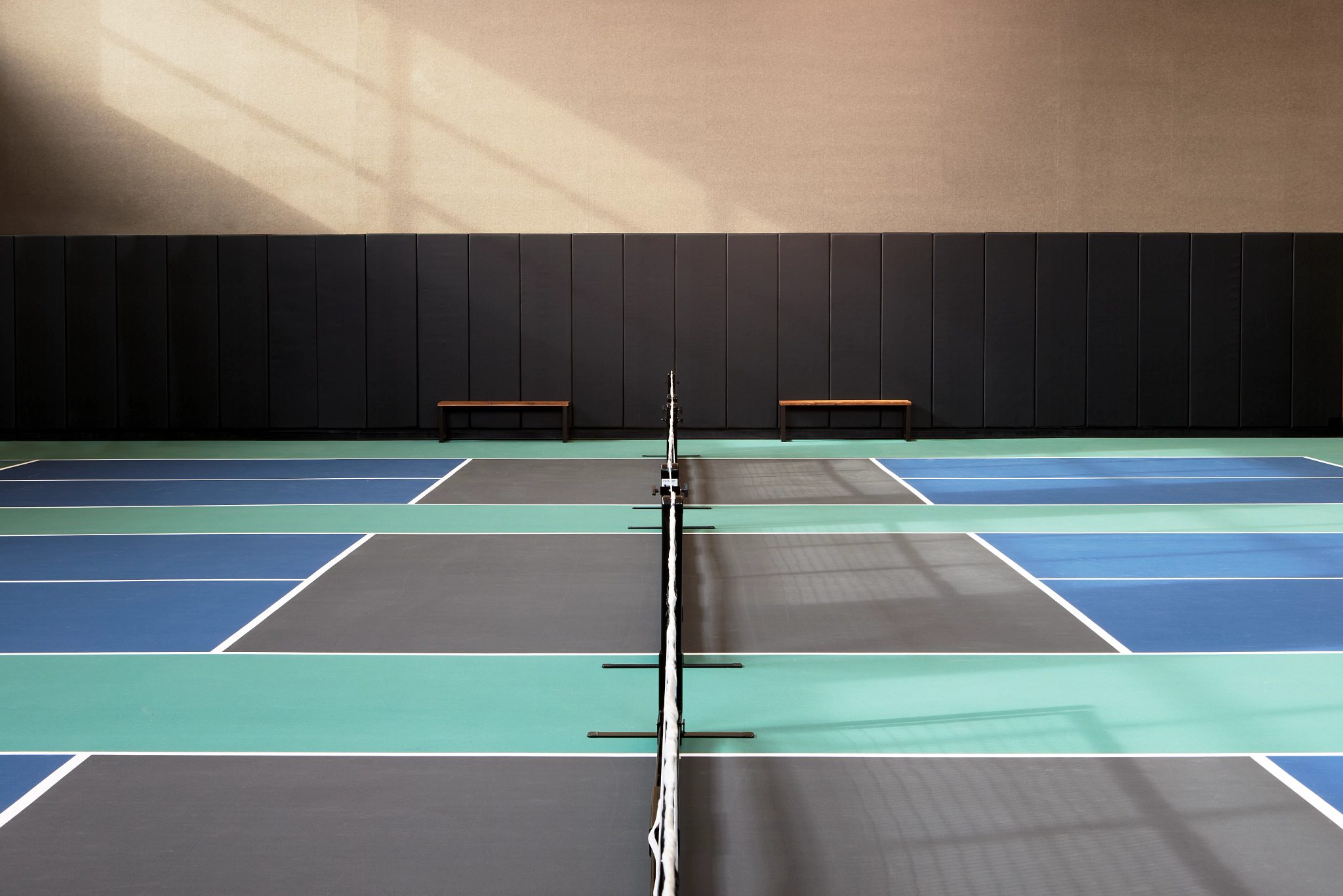 3 indoor pickleball courts with benches