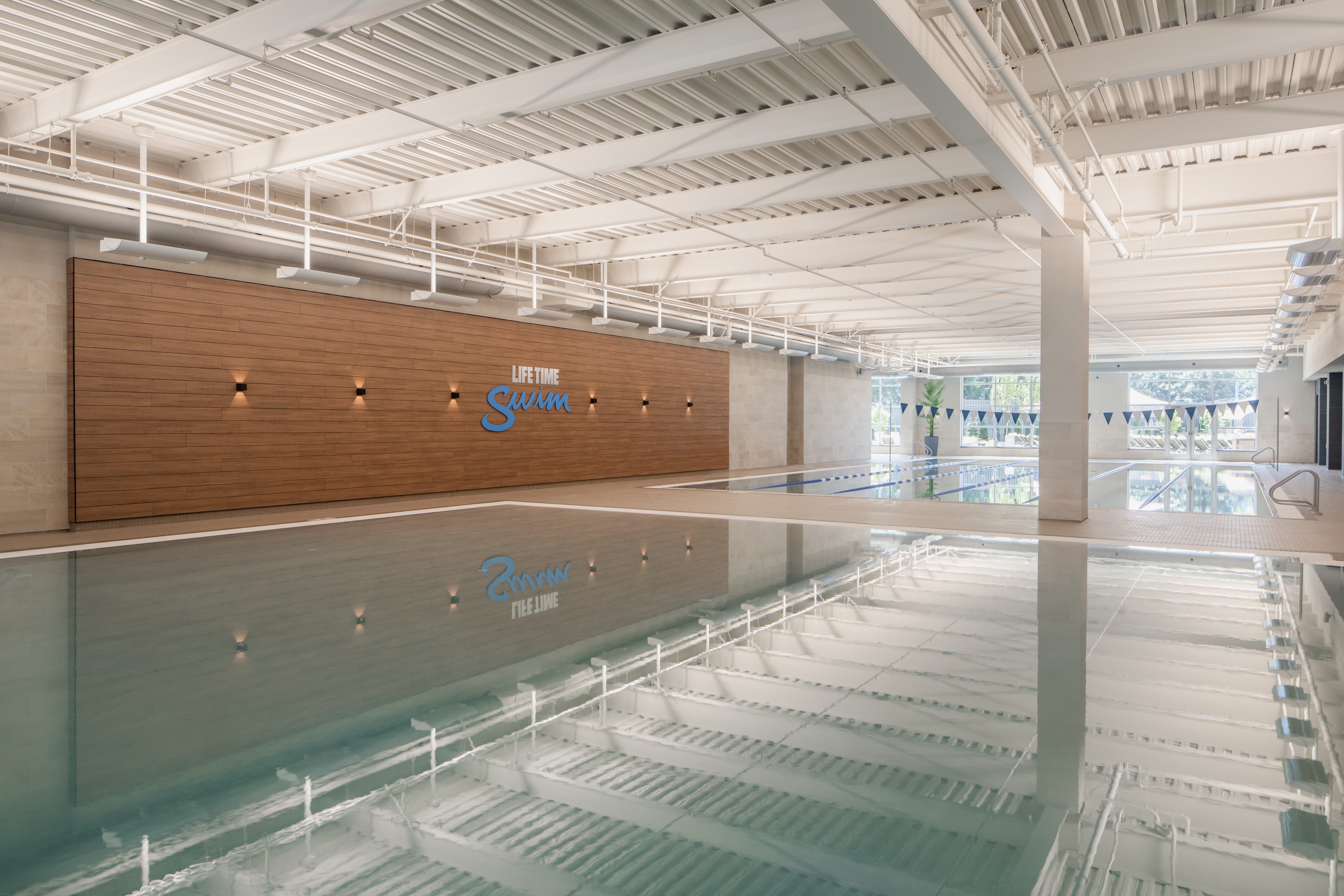 Brightly lit indoor leisure and lap pool at Life Time