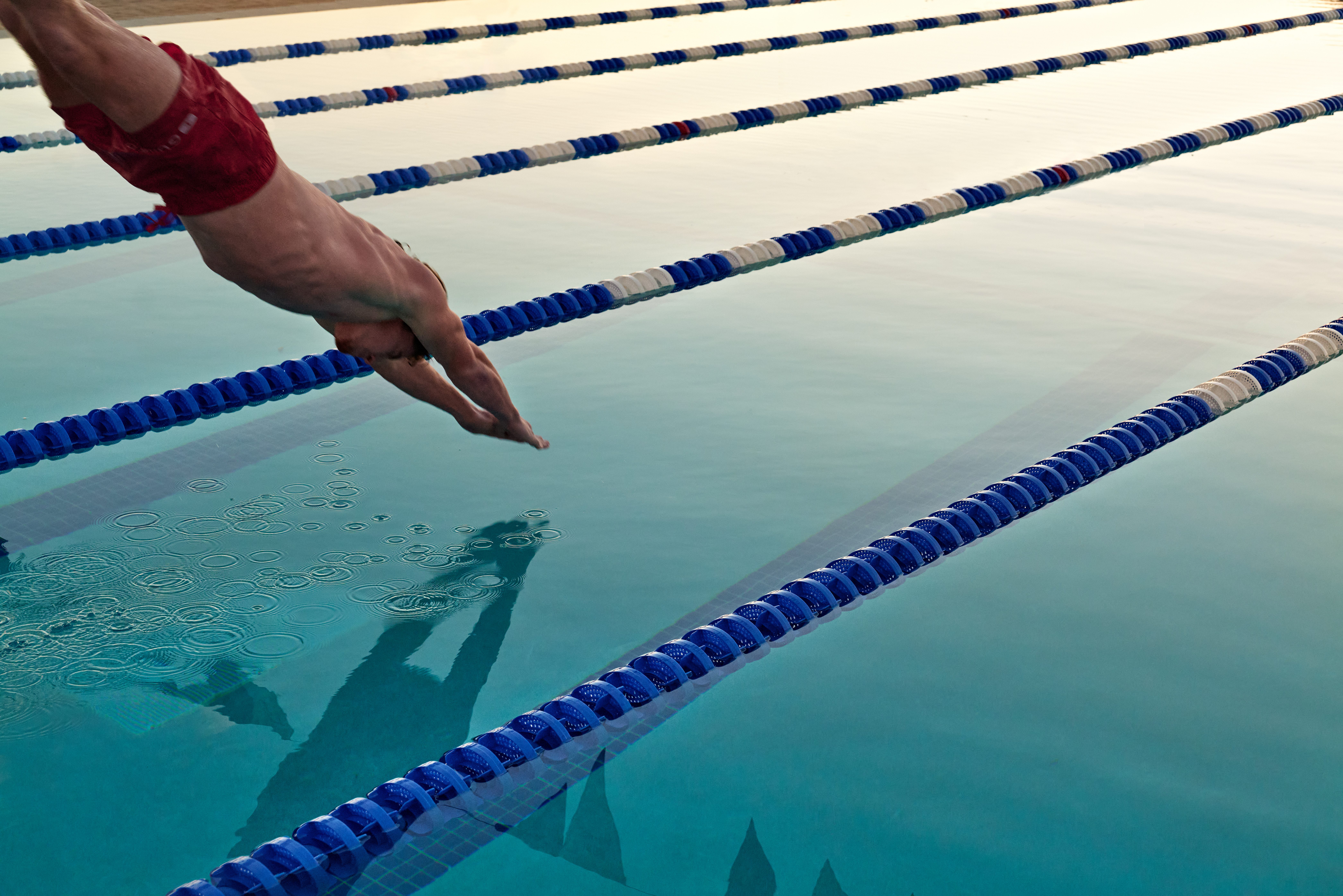 A man dives into a lap pool