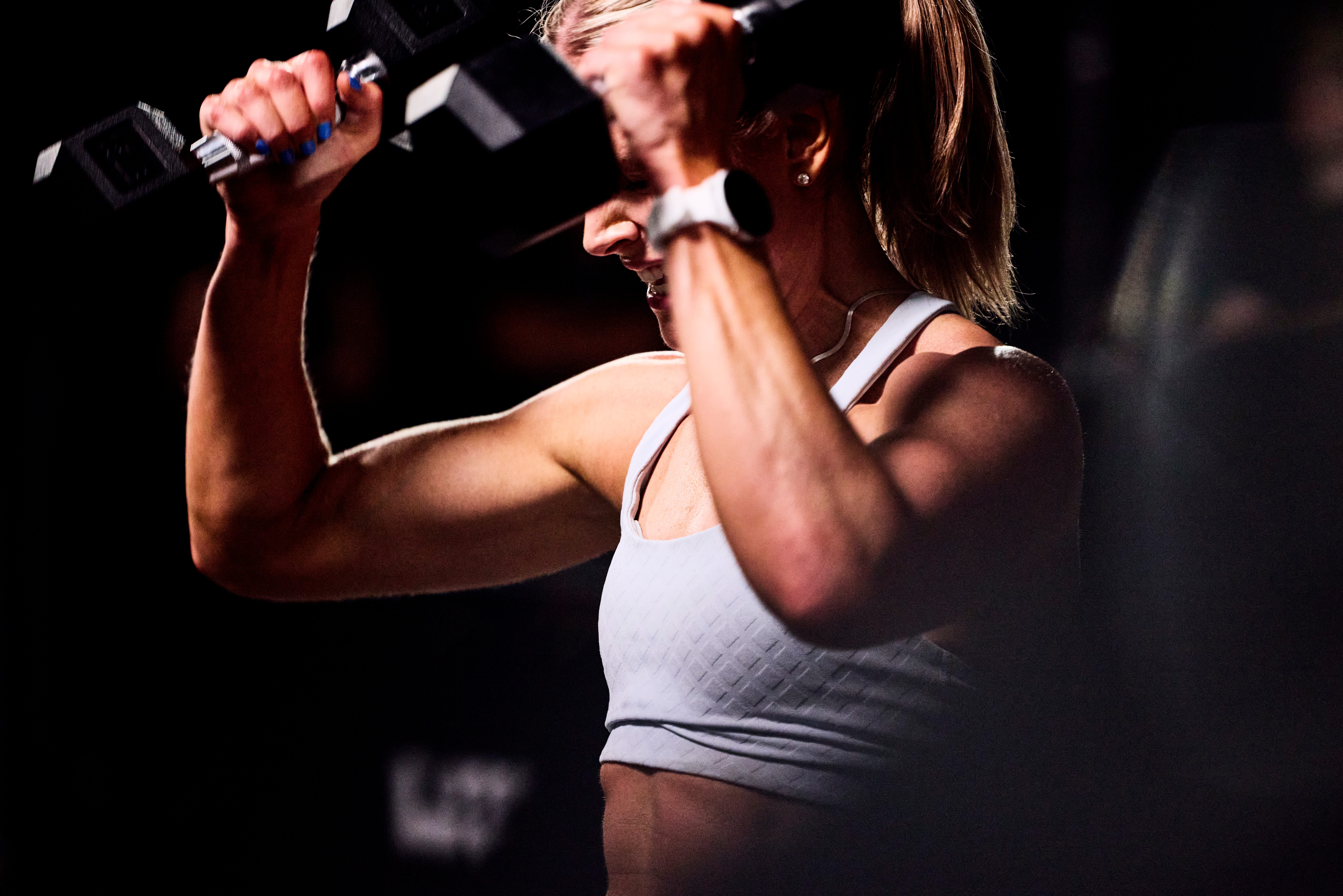 woman holding two dumbbells in her hands