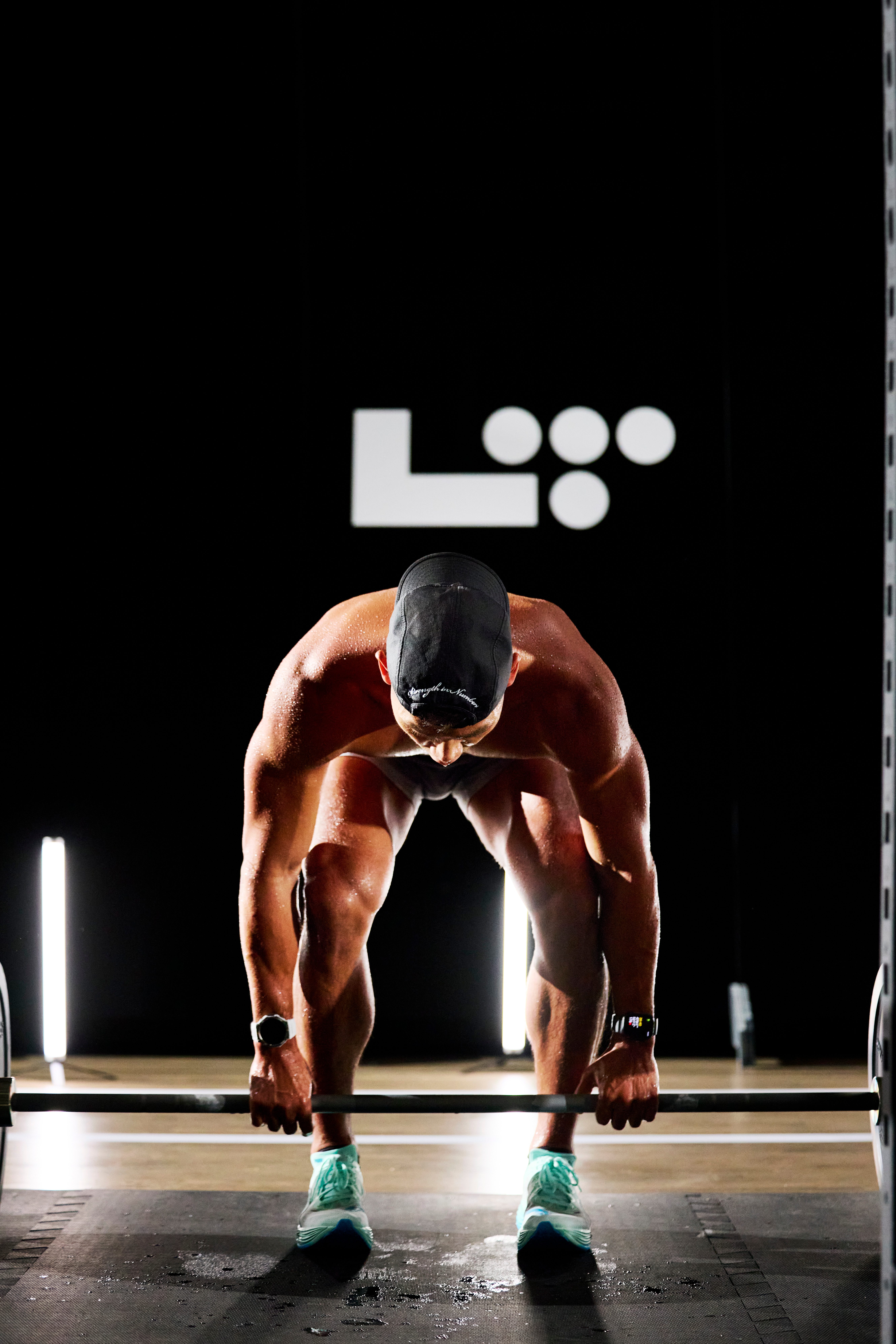 man squatting down grabbing a barbell