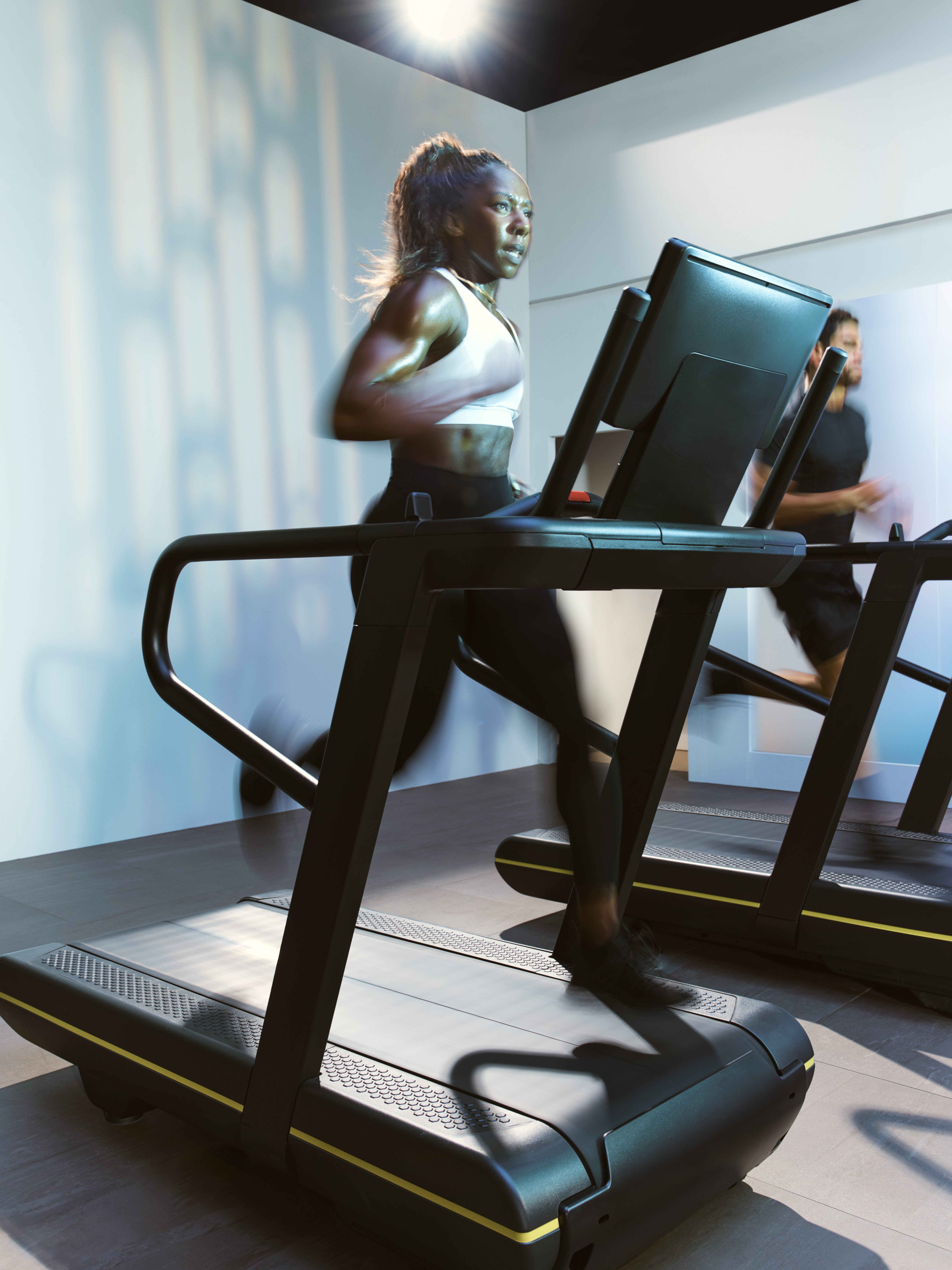 Woman sprinting on a treadmill in the UltraFit boutique group training class