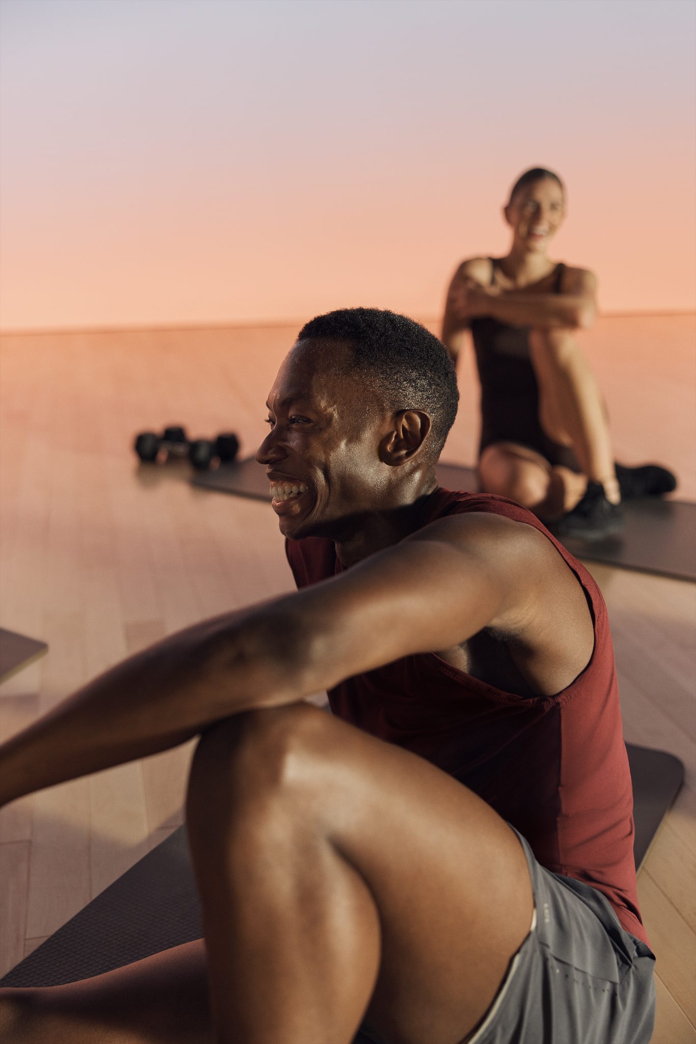 Close up of a Shred strength class participant smiling while seated on their mat