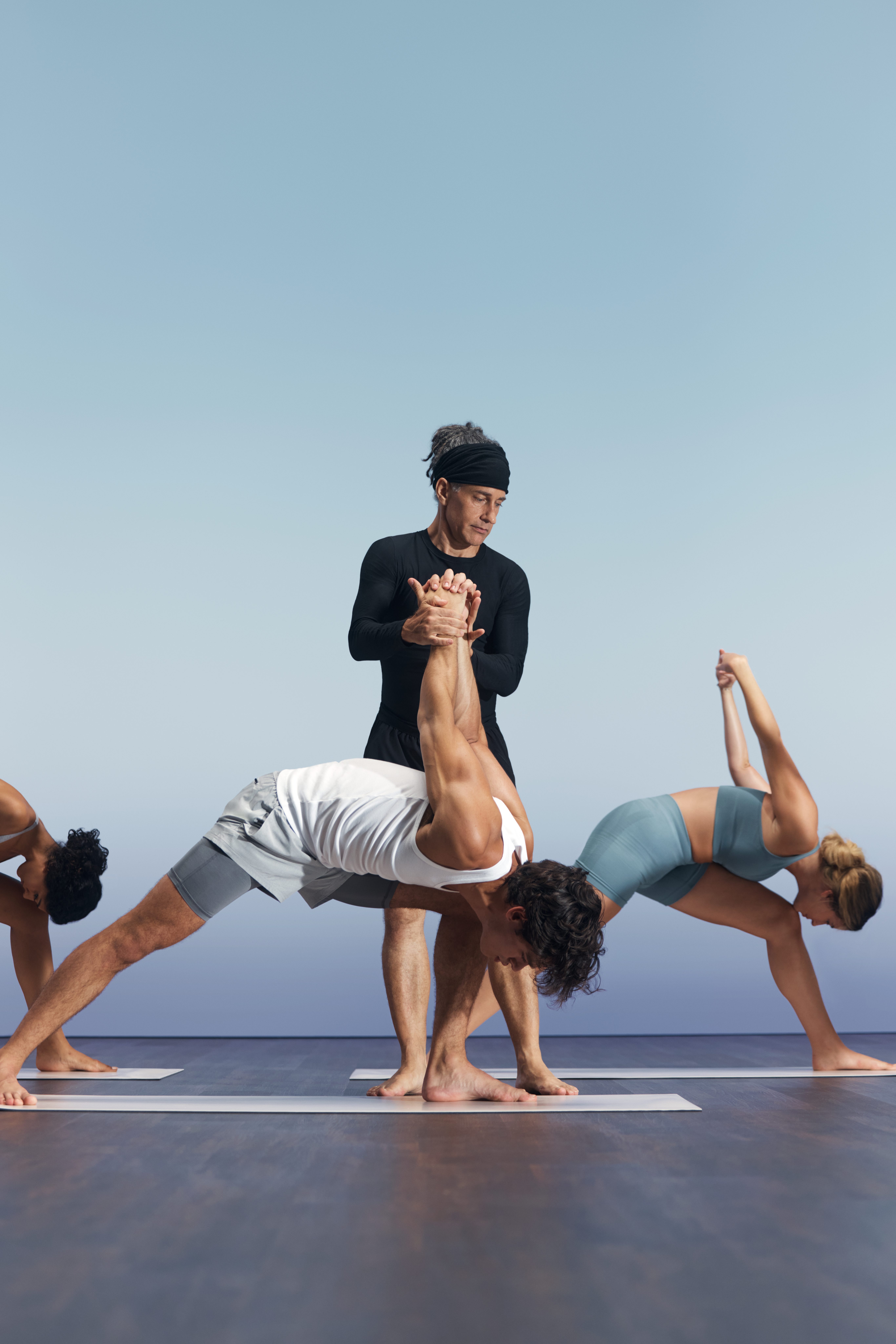 Sol yoga instructor guiding participant in foreground at Life Time